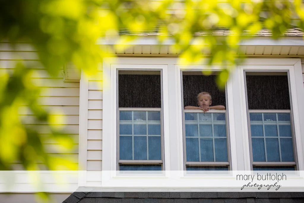 Boy watches from the window of his home at Skaneateles