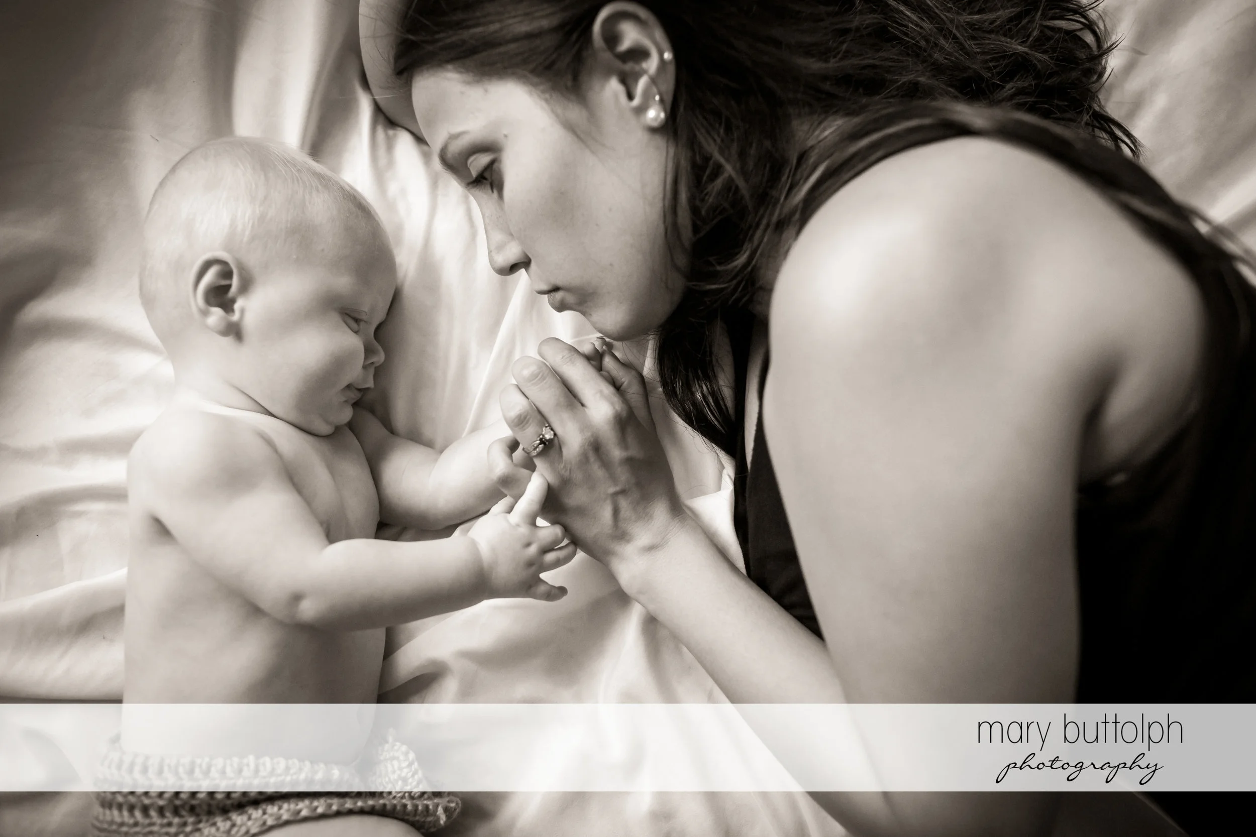 Baby playing with mother's hands at Skaneateles Family