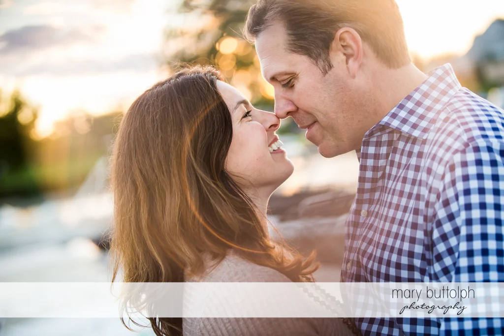 Couple rub noses near the lake at Skaneateles Country Club