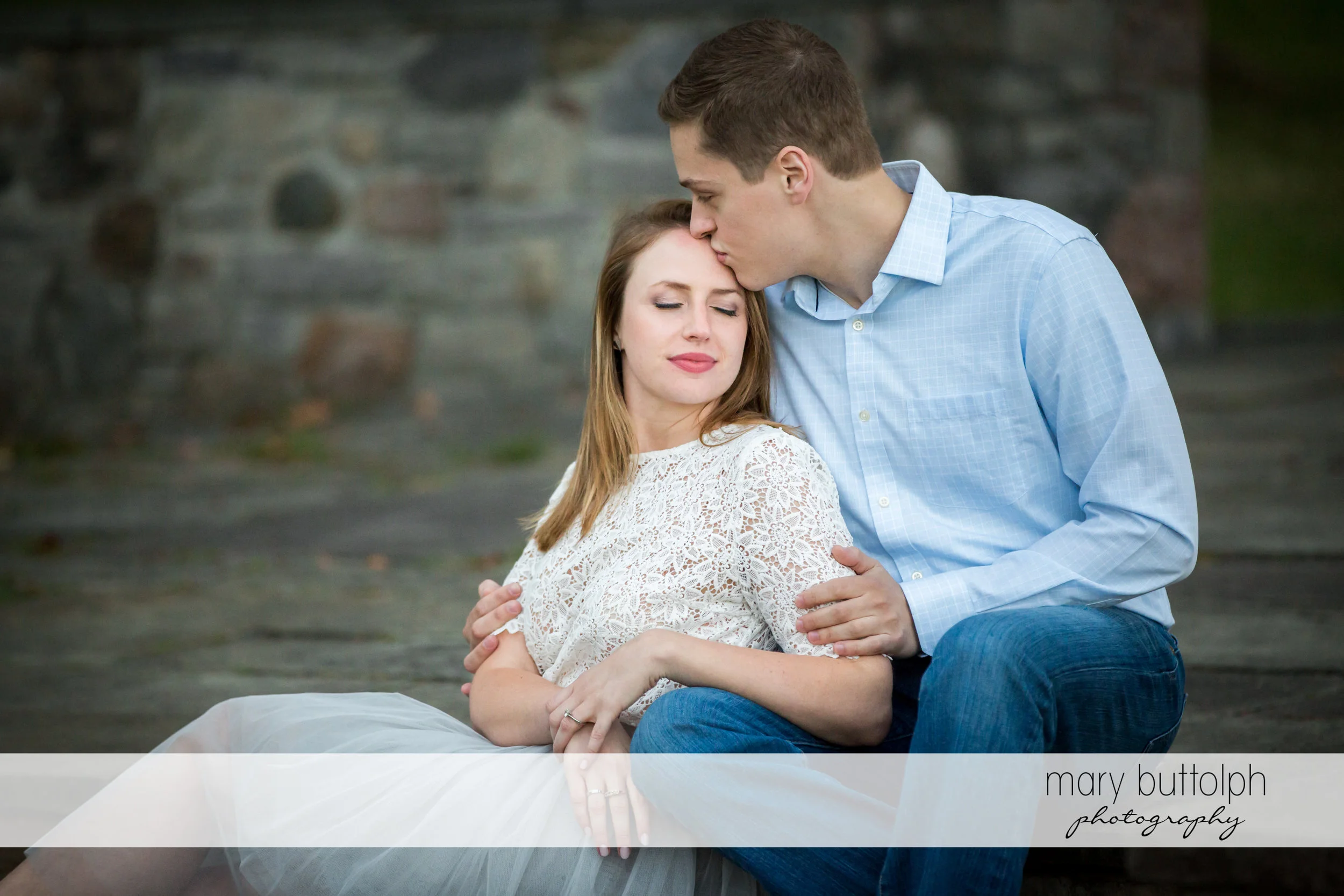 Man plants a kiss on his fiance's forehead at Skaneateles Engagement