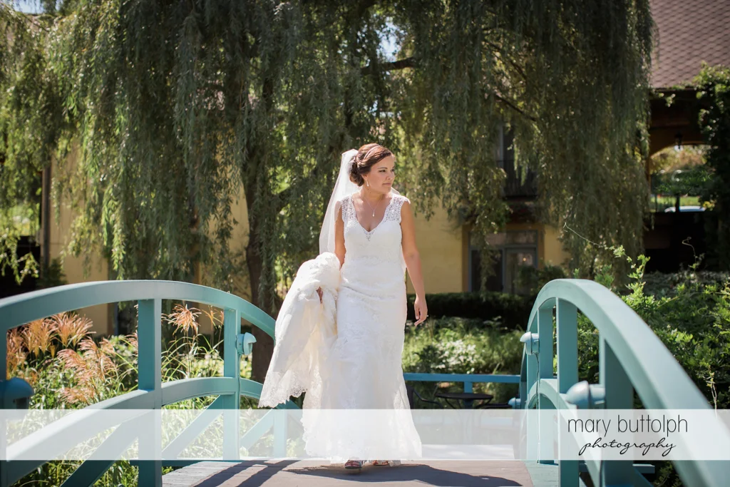 Bride crosses the bridge at The Lodge at Welch Allyn Wedding