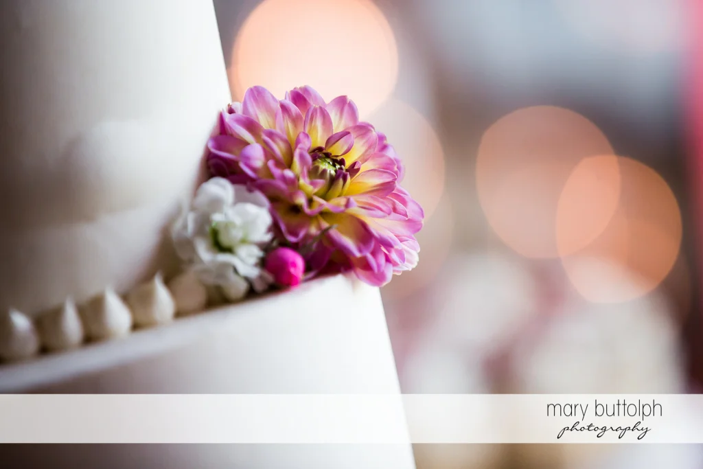 Wedding cake is decorated with flowers at The Lodge at Welch Allyn Wedding