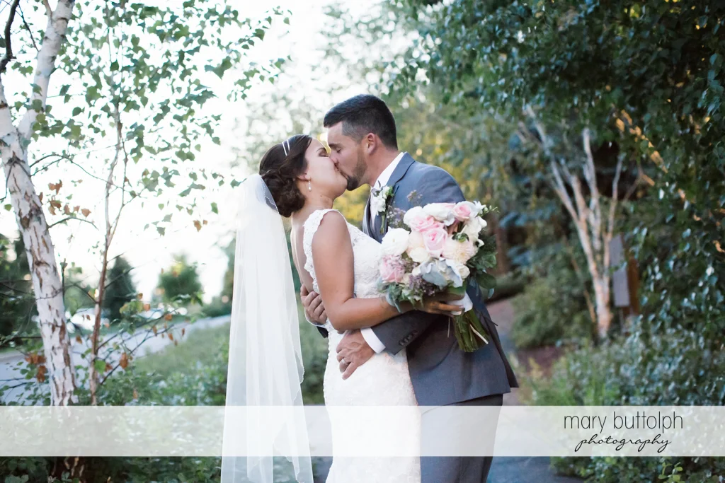 Couple show their affection in the woods at The Lodge at Welch Allyn Wedding