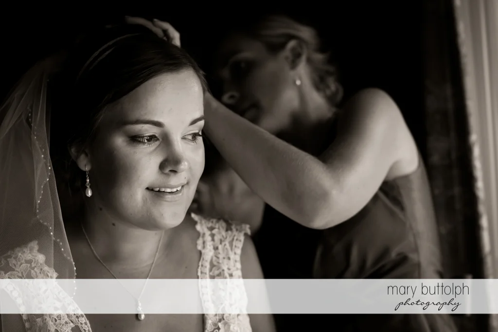 Woman attaches the bride's wedding veil at The Lodge at Welch Allyn Wedding