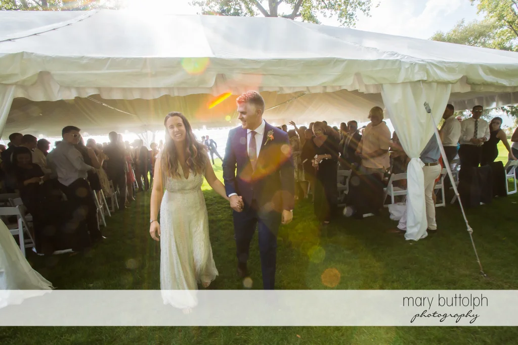 Couple take a walk after the wedding ceremony at Aurora Inn Wedding