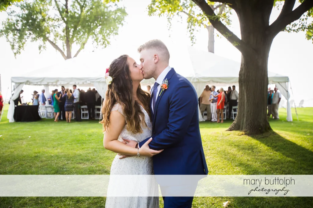 Couple kiss in front of guests at Aurora Inn Wedding