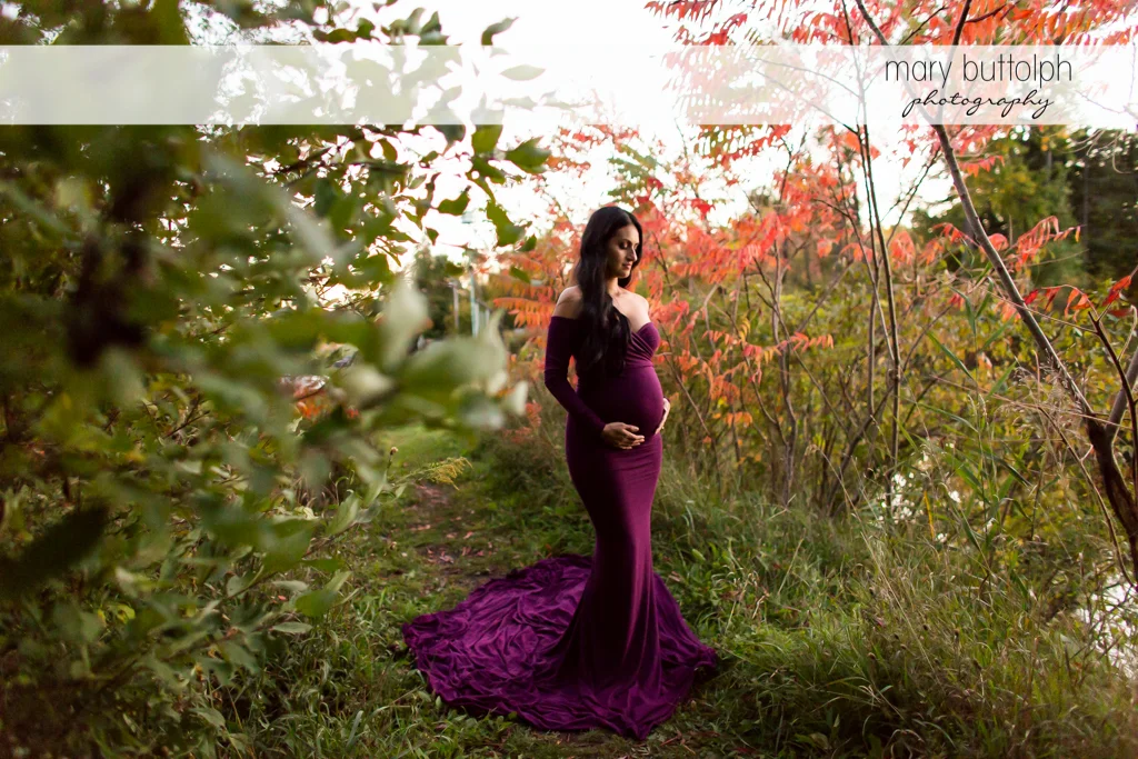 Woman in gown with baby bump in the garden at Skaneateles Maternity Photography