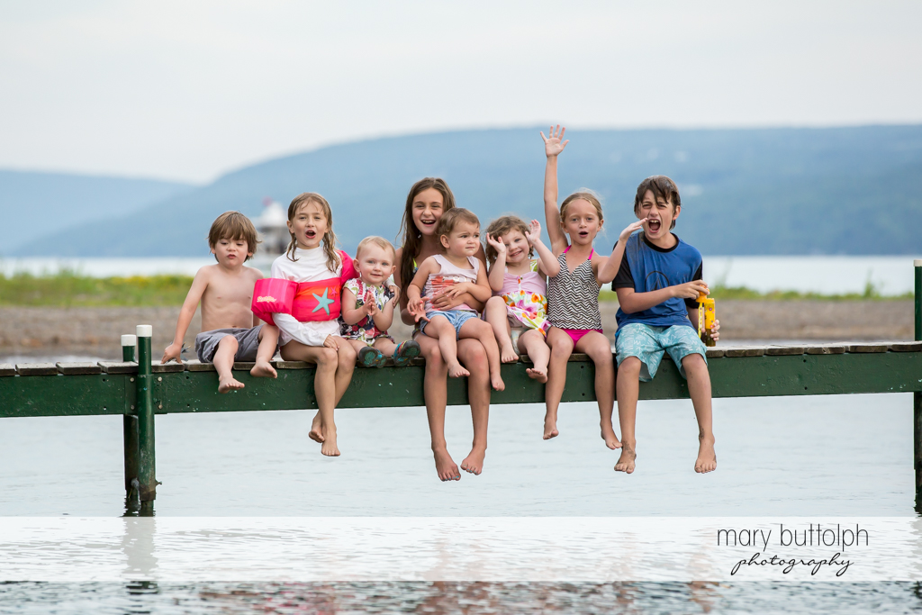 Kids sitting on a dock at Skaneateles Lake