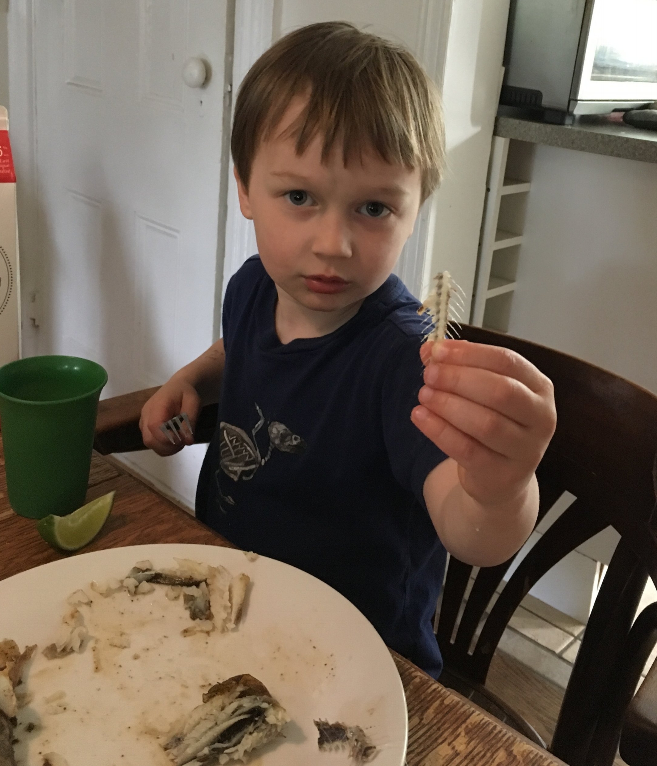 Cash at dinner tonight, showing me the spine of the fish. That's the head on his plate - you can see the head more clearly in the title photo of this post. 