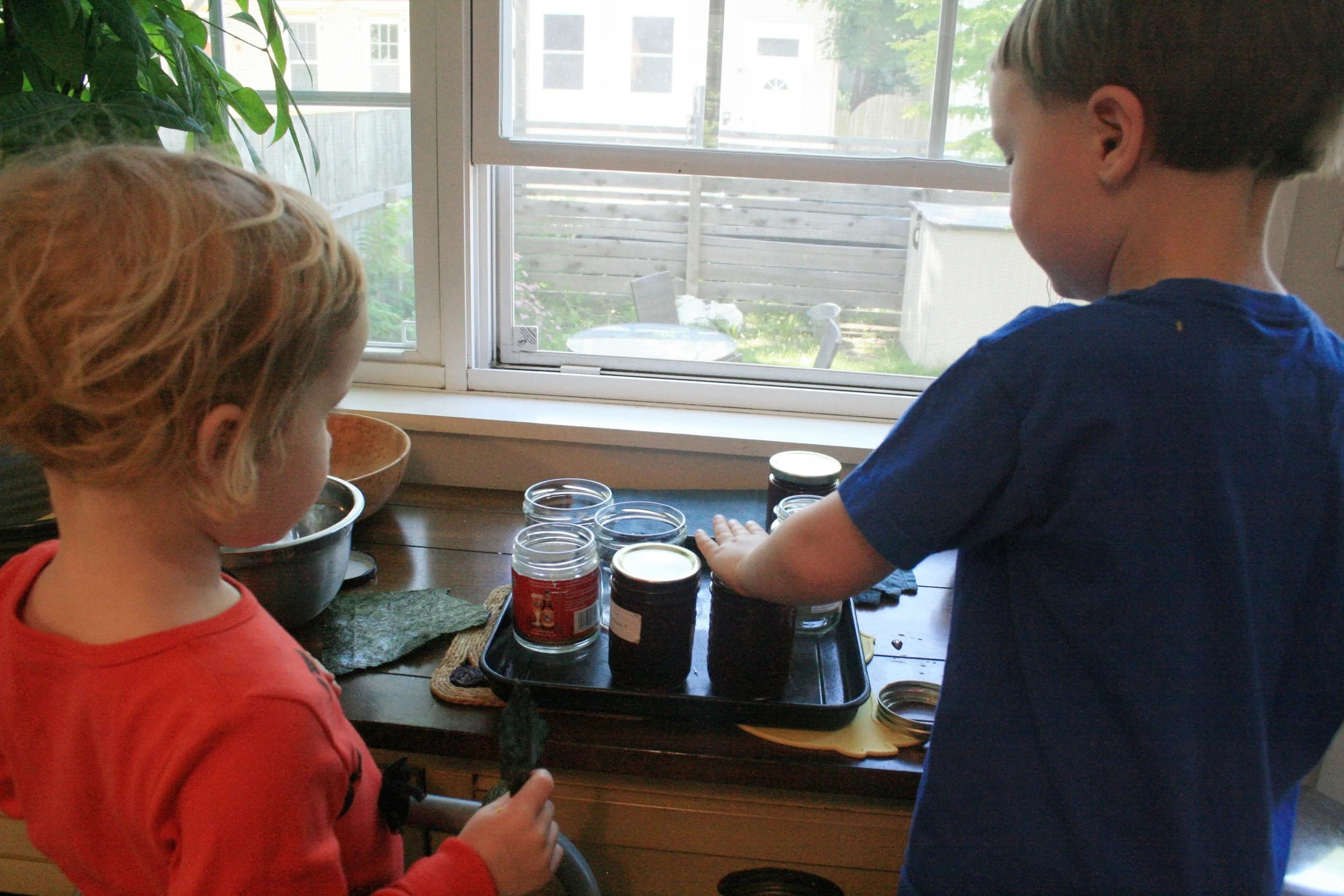 Pressing the lids down. Take care - the jam, and the jars, are hot!