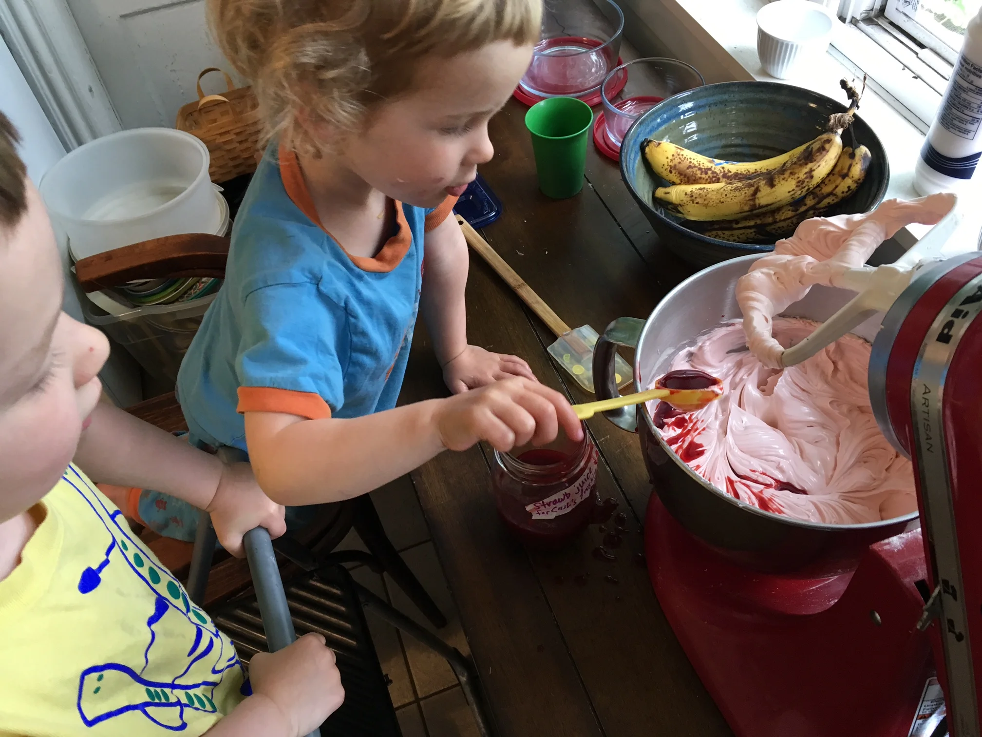 Morning of the party: adding strawberry juice to the vanilla buttercream, to achieve the pink hue.