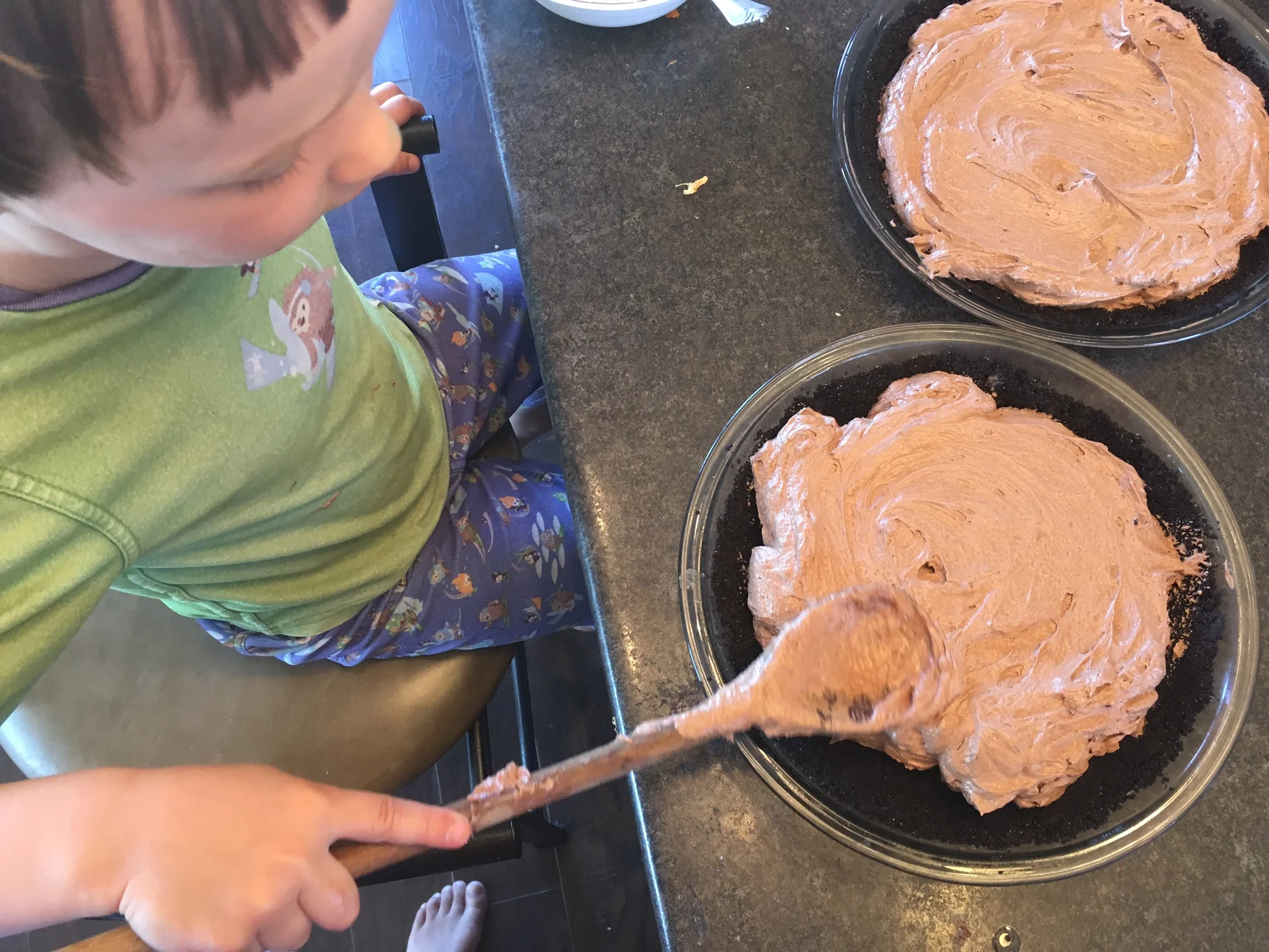 Cash smoothing the tops of the Chocolate Cream Pies. On holidays, we work in our pyjamas, of course.