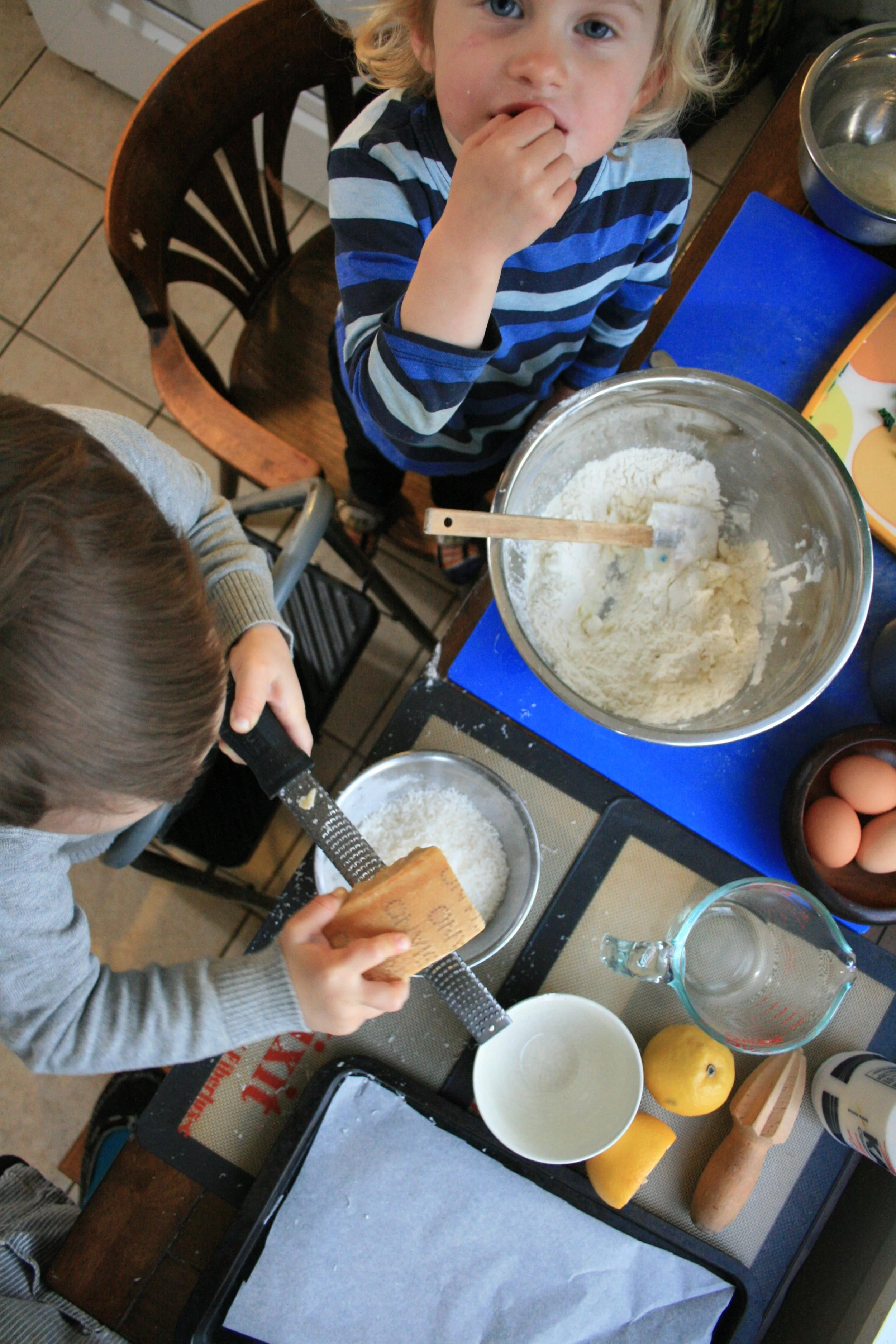 Cash grating Parmesan, Polly snacking on cooked spinach