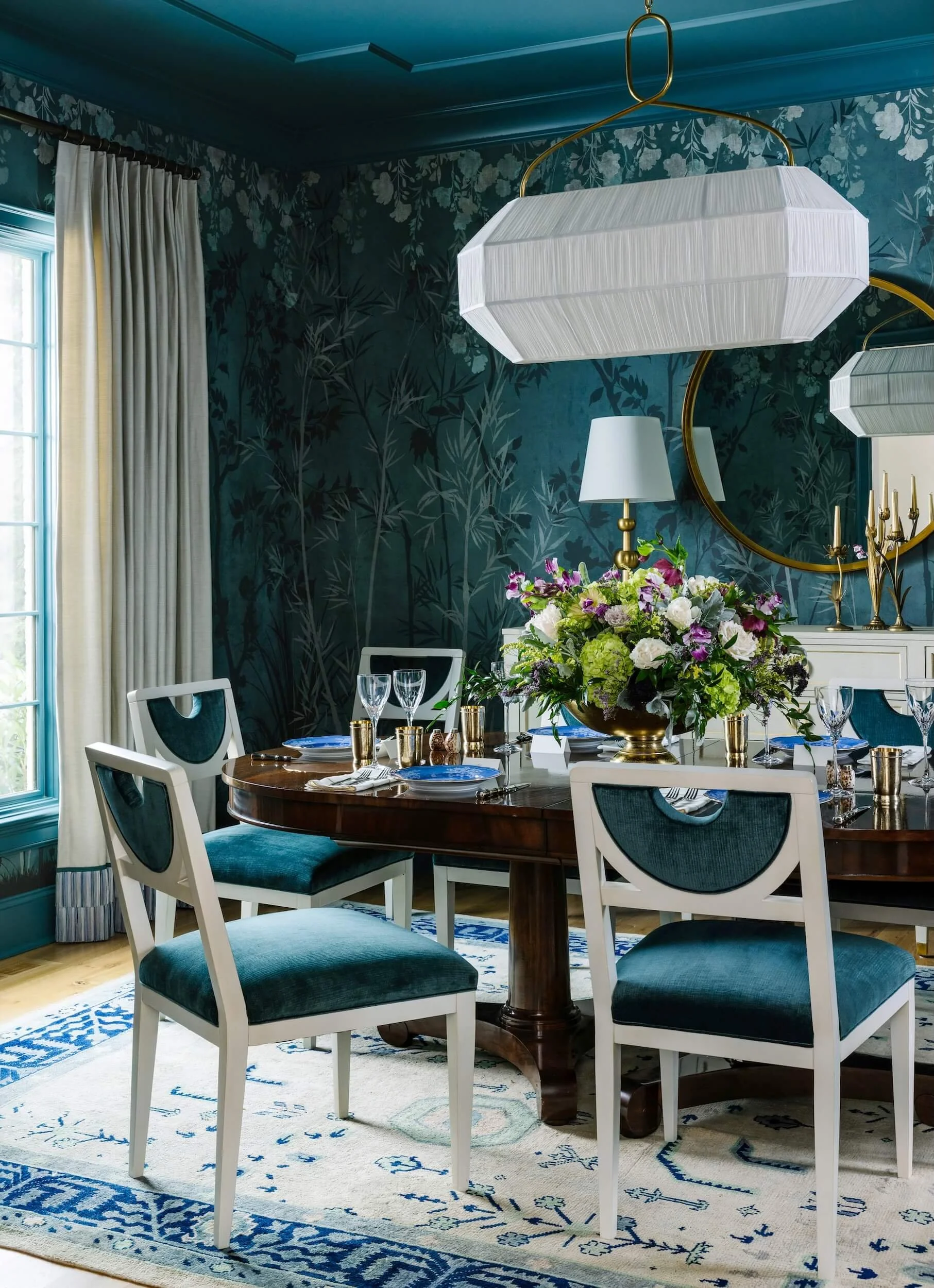 Detailed view of velvet dining chairs, rug, and white light fixture