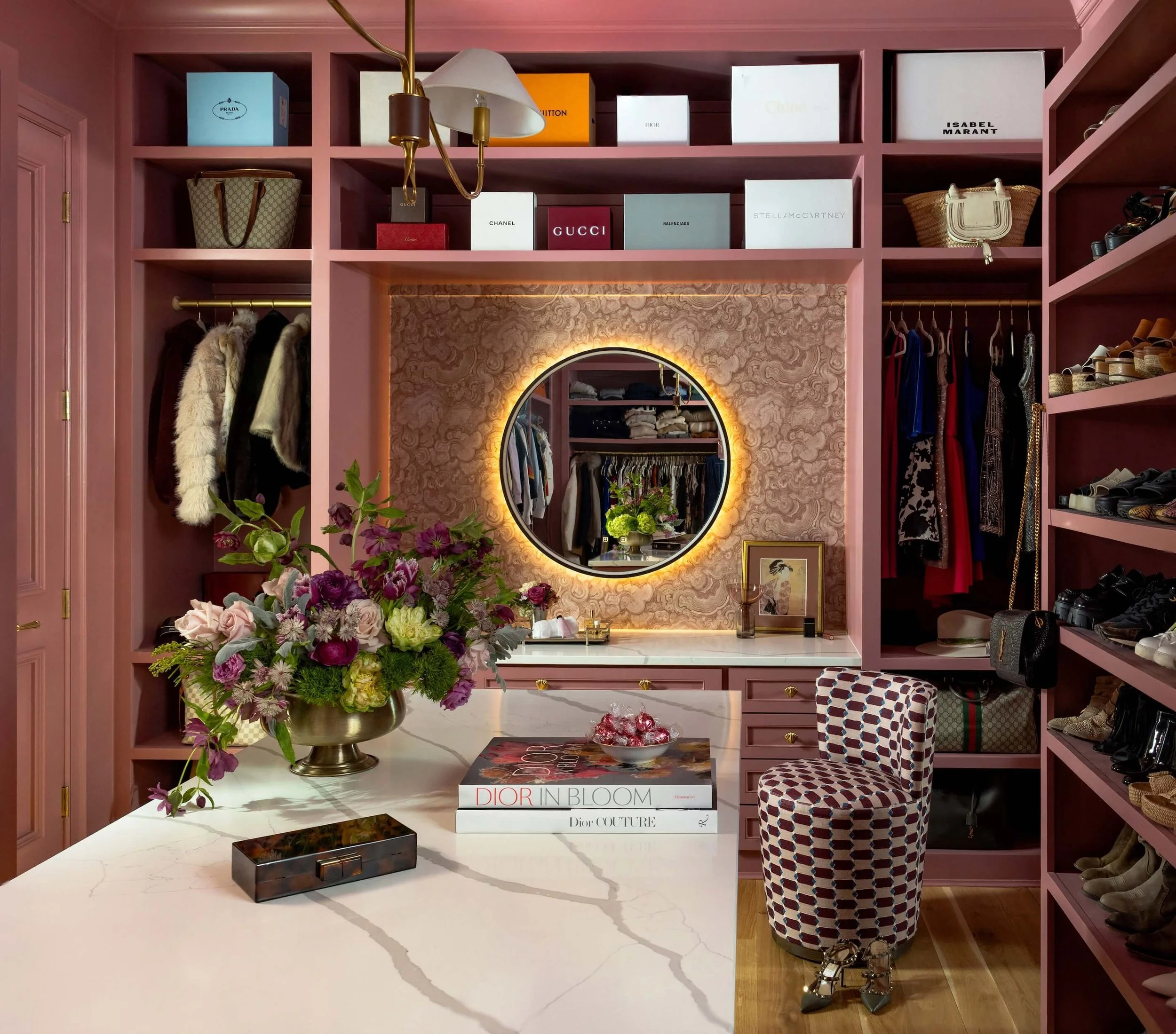 A pink color drenched closet with marble island 