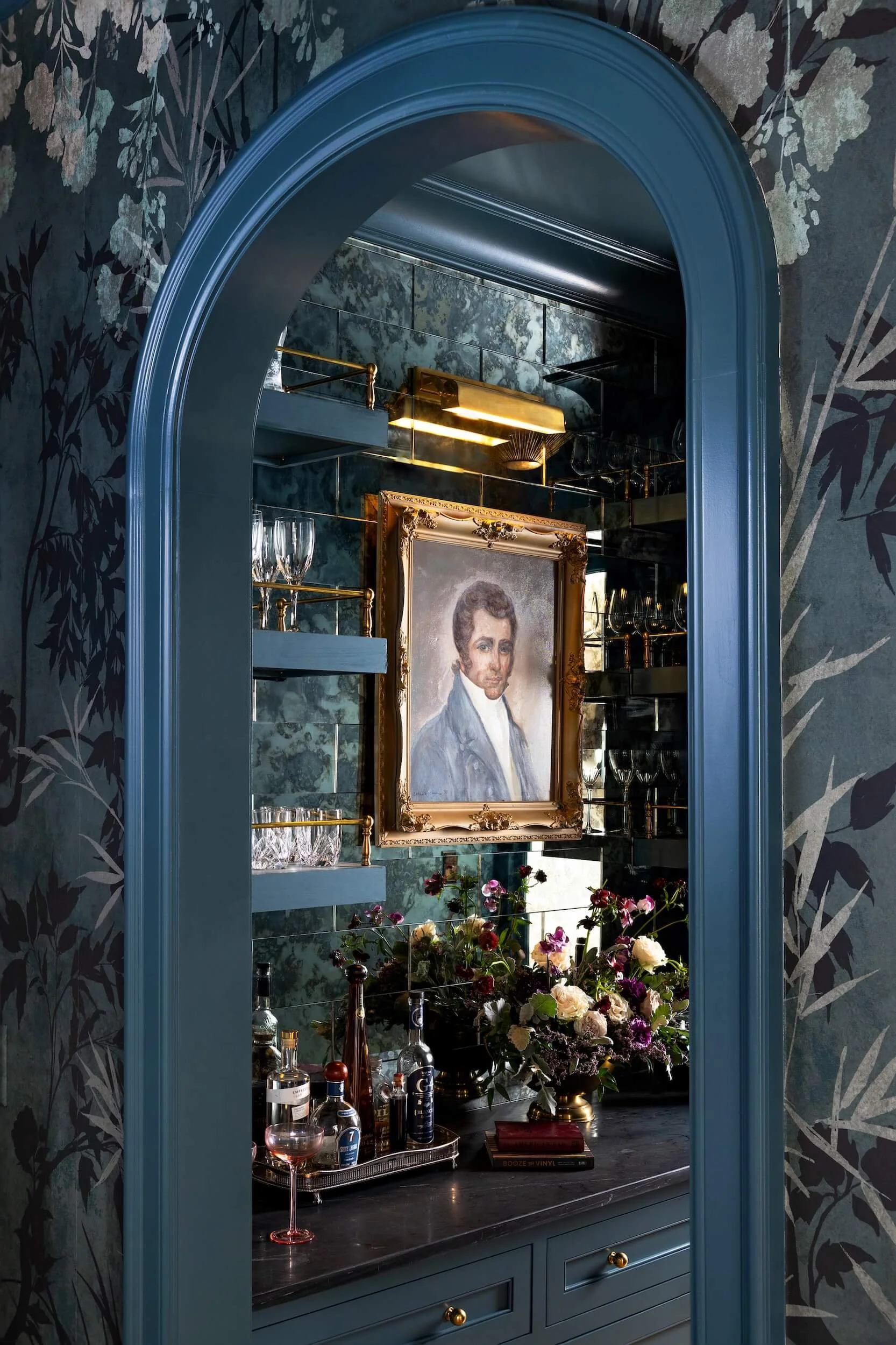A view of the butler's pantry through a blue, arched door frame