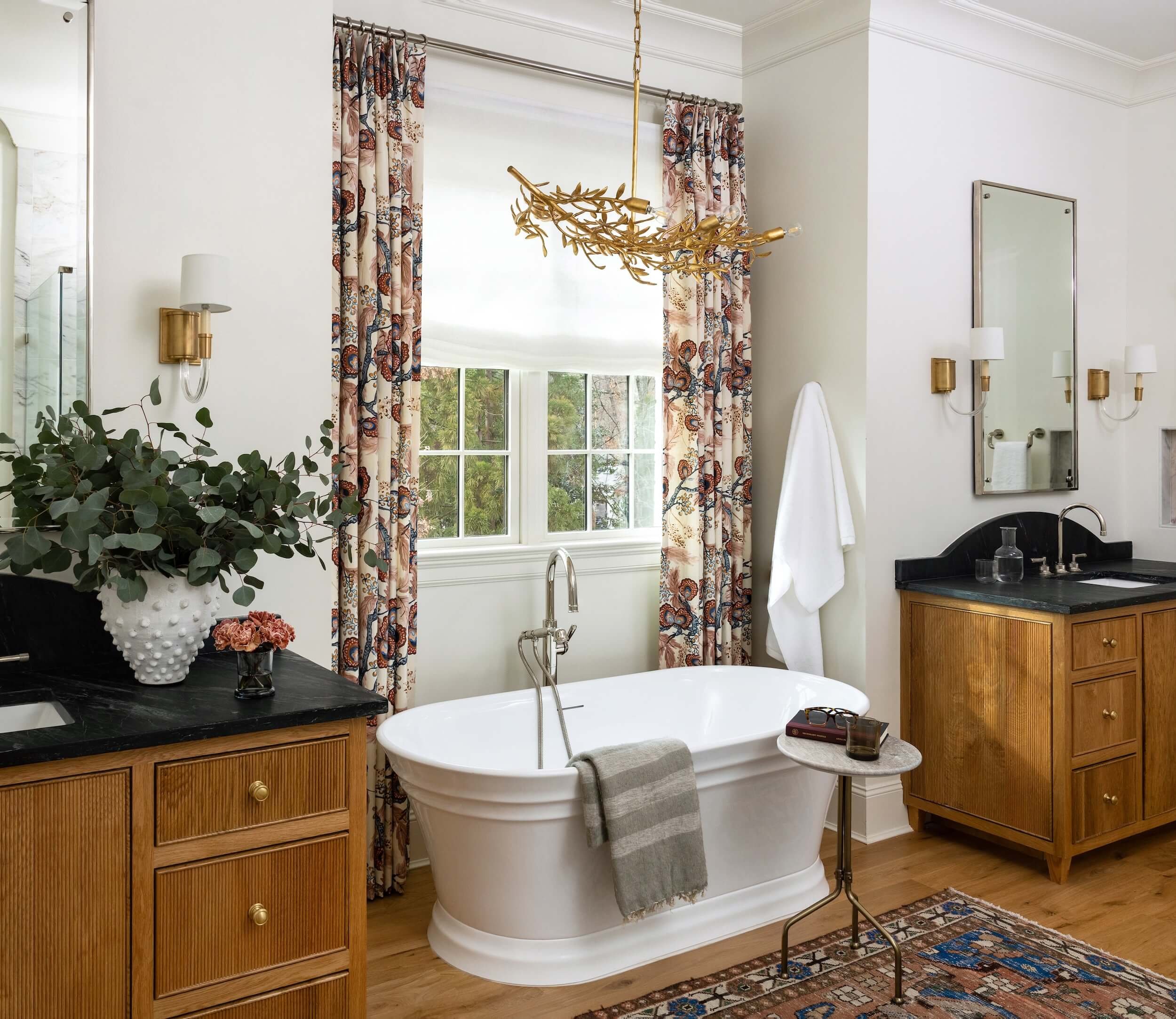 A freestanding tub between the two vanities in the primary bathroom