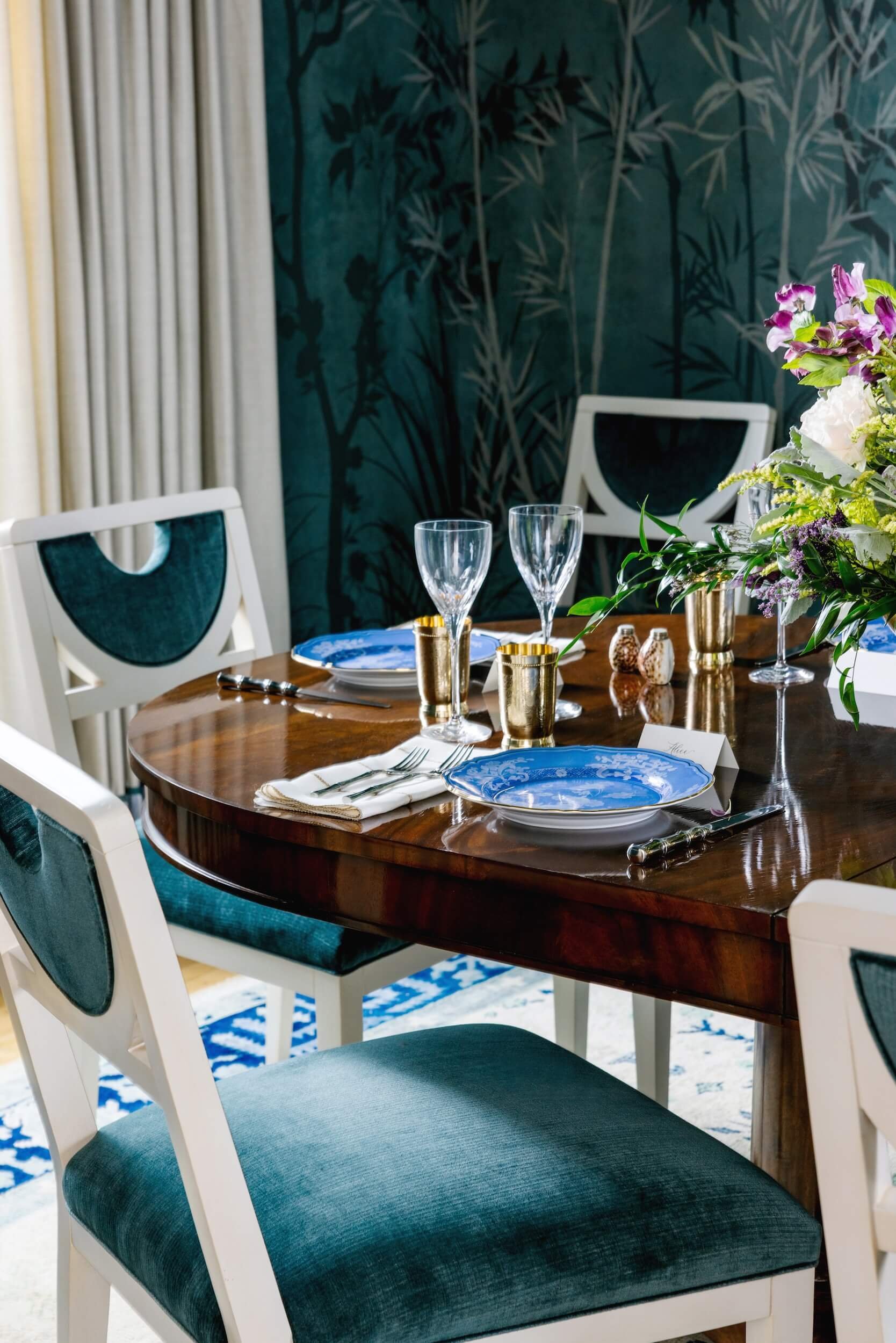 A look at the tablescape with teal velvet chairs,  bright blue china, and beautiful flowers