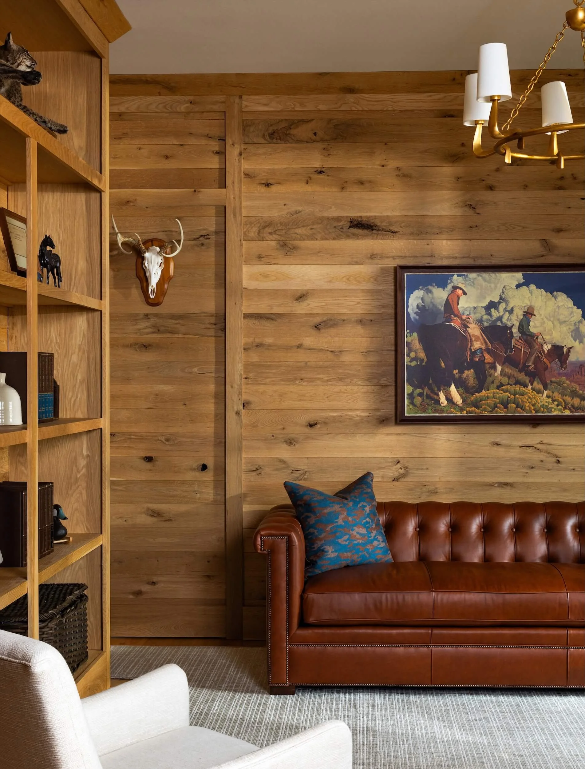 A view into the wood paneled sitting room with bookshelf in view