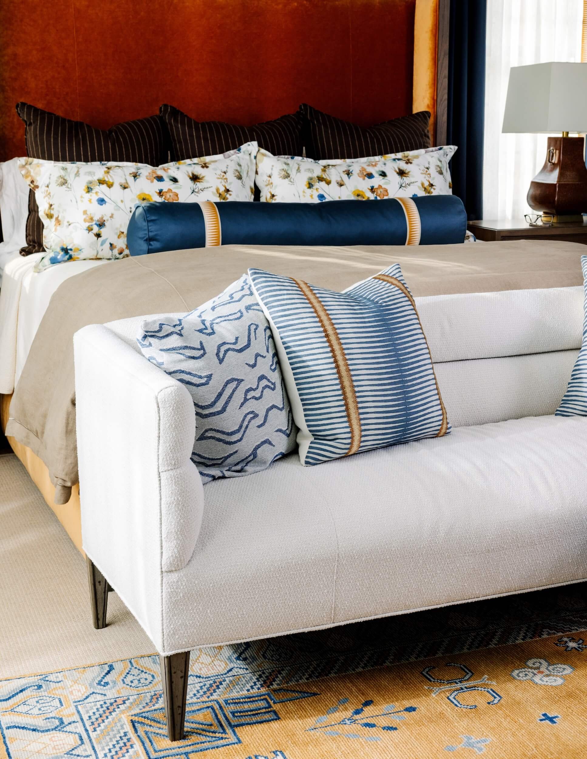 A close up of the white couch at the foot of the bed
