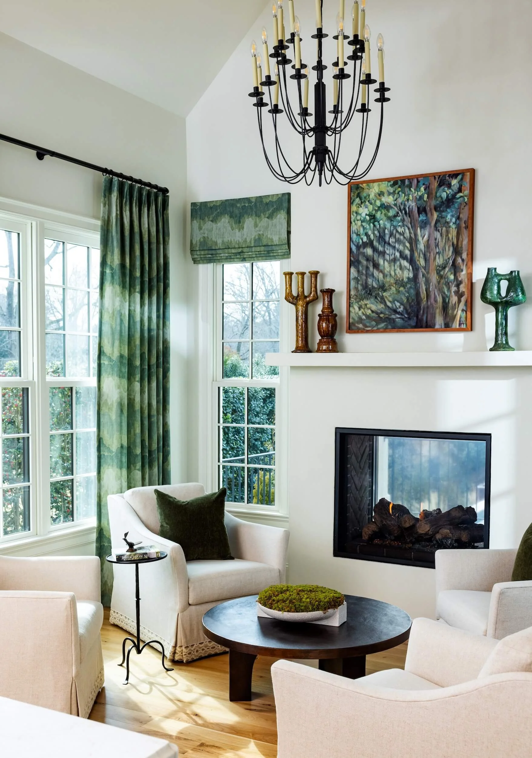 A view into the corner of the white sitting room with green accents 