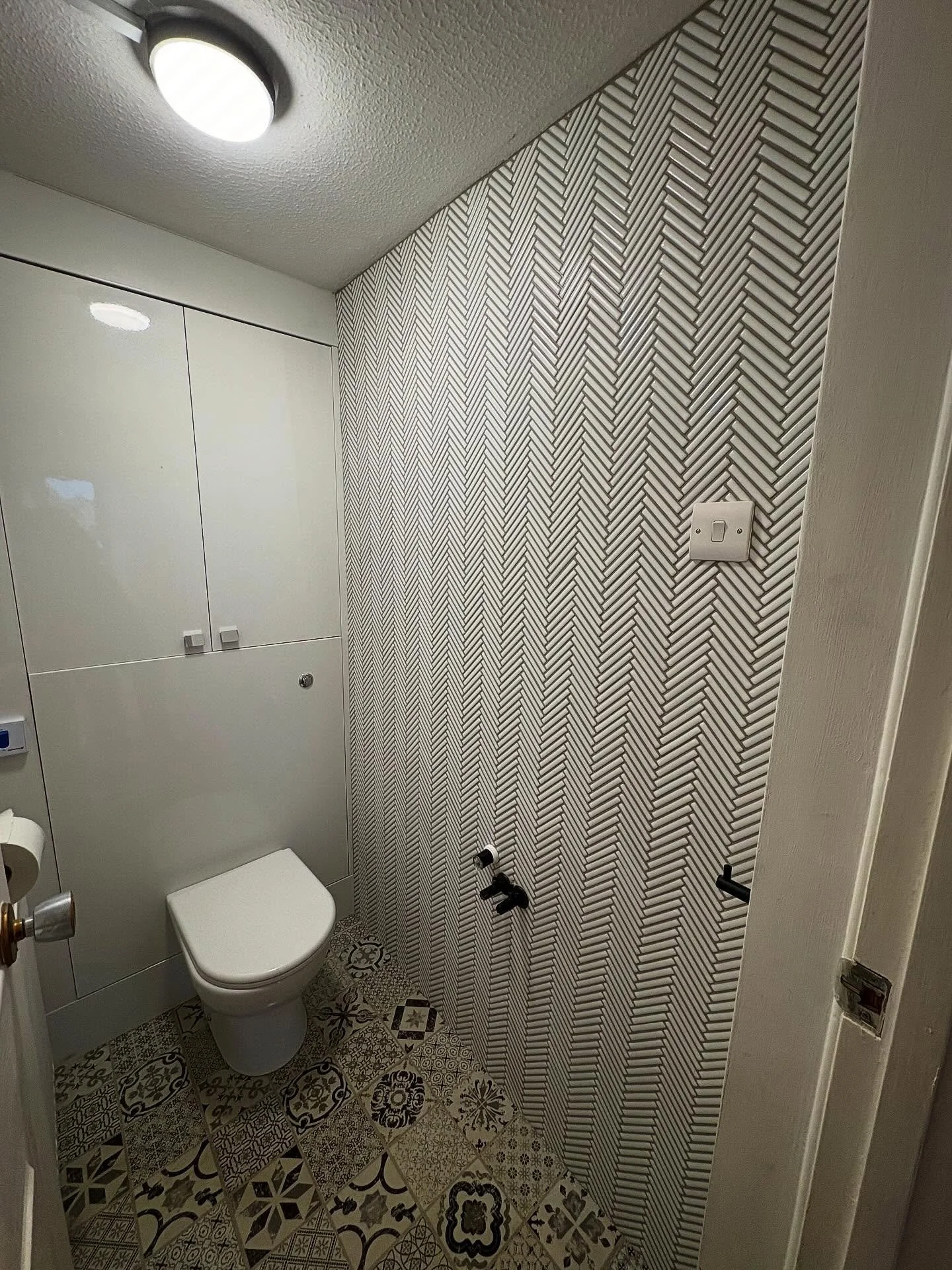 Small toilet wall tiling in herringbone mosaic tiles. The customer had a leaking sink replace and old tiles taken off but a plumber , but because mosaics were  going back on, we replaced the whole lower section of boarding to provide a clean surface 