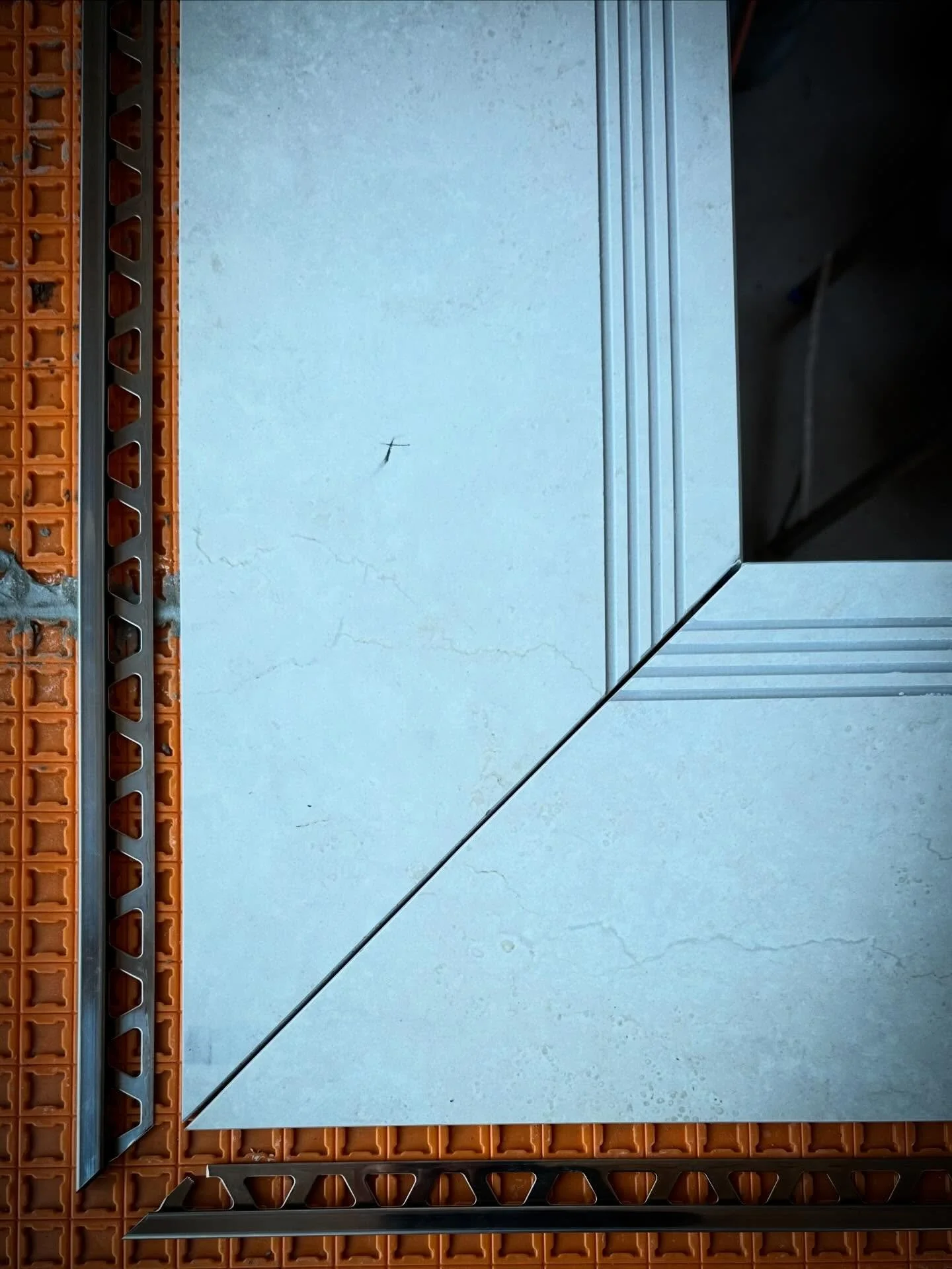 Bespoke coping tiles being dry cut in with the @schlutersystemsuk stainless steel box section trim detail to frame the pool. #tiling #tilers #tiles #nottinghamtilers #swimming_pool