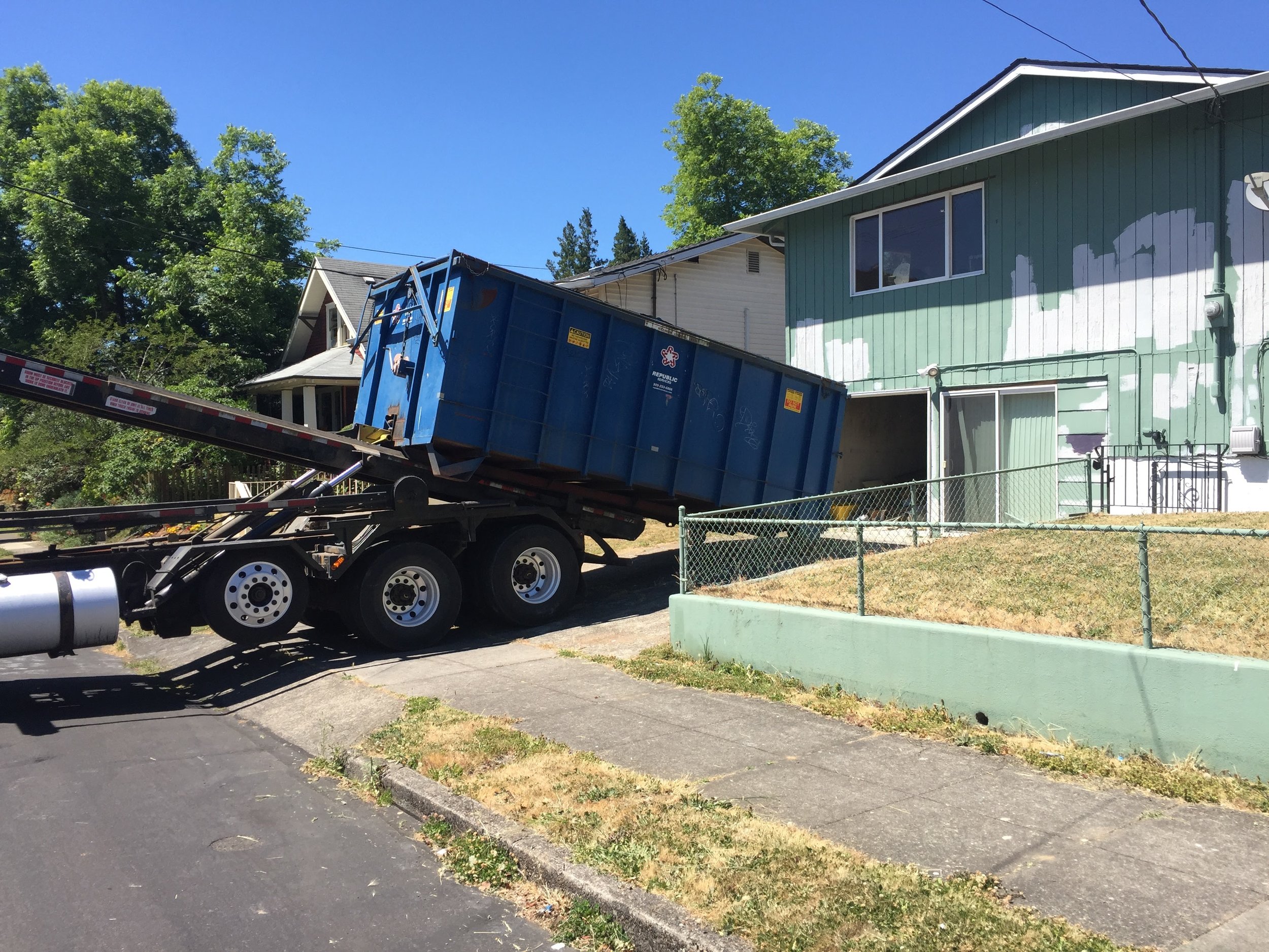 Here's a dump truck being delivered. They charge by the weight. This dump has capacity for 30 yards of waste. 3000 pounds of waste picked will cost ~$500. This is way cheaper and easier than hauling all of this waste to the dump myself. 