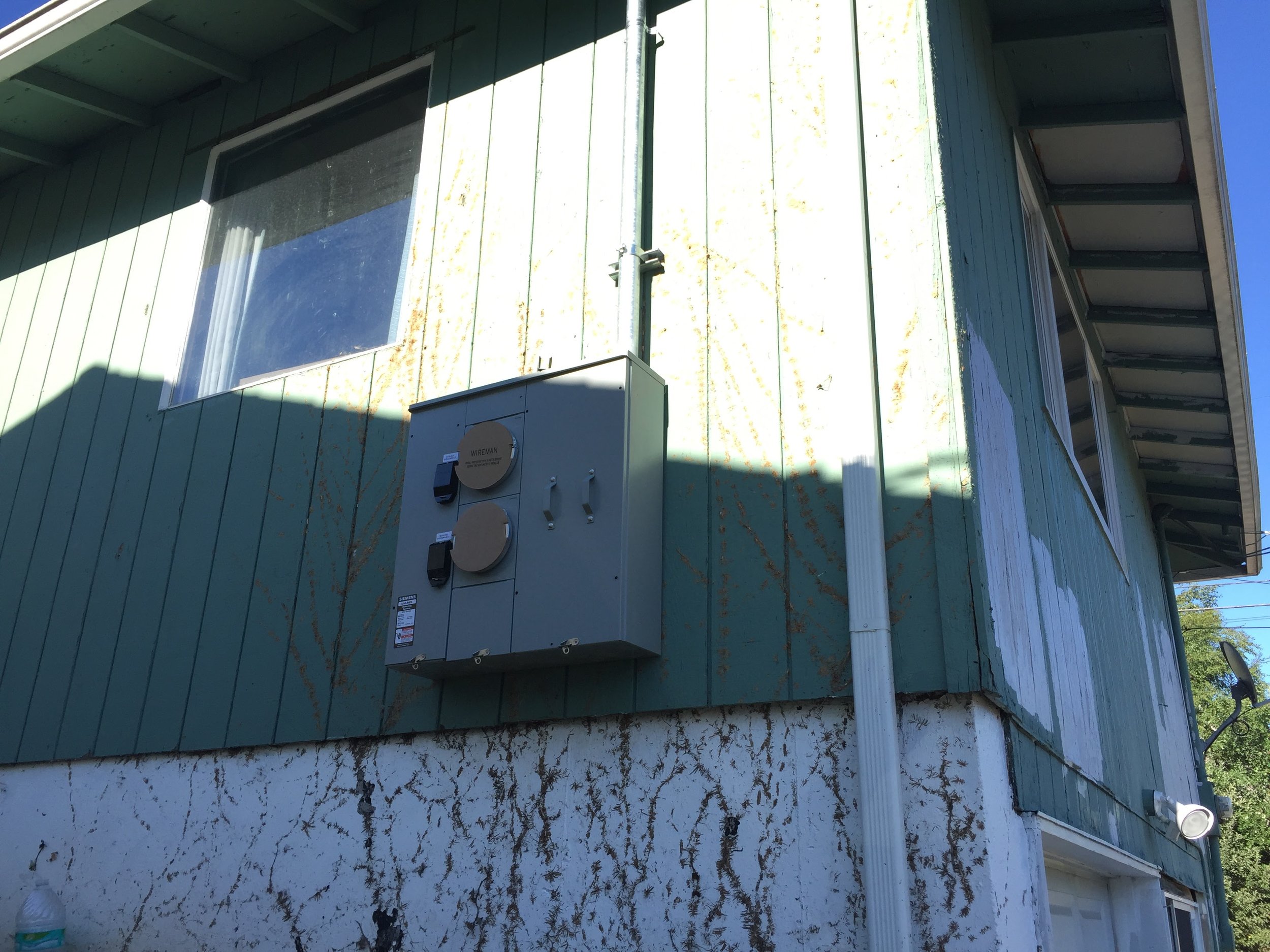 A dual pac or two pack meter head was installed on the exterior of the house. One meter will feed the panel for the upstairs unit. One meter will feed the panel for the downstairs unit. 