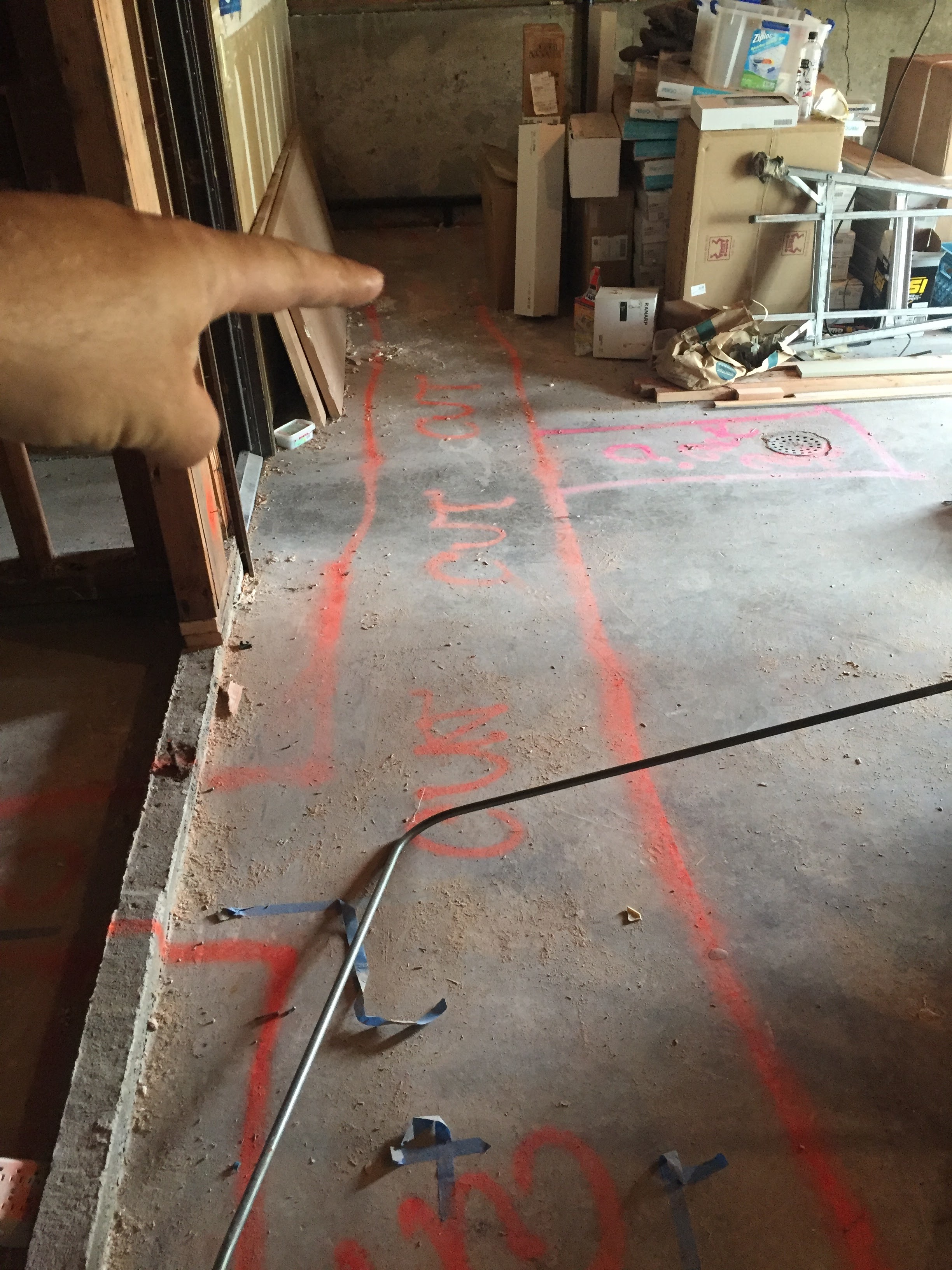 The spray paint marks on the ground are where trenches will need to be cut in order to lay down new ABS drain lines for the bathroom. 