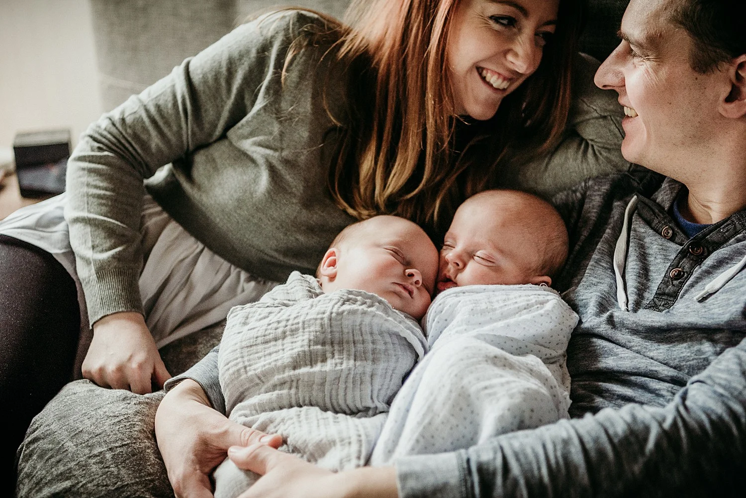 laughing parents of twin babies