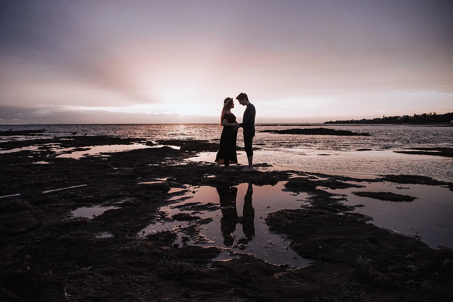 pregnant couple in the sunset