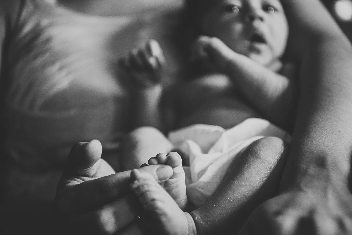 mother playing with babies feet