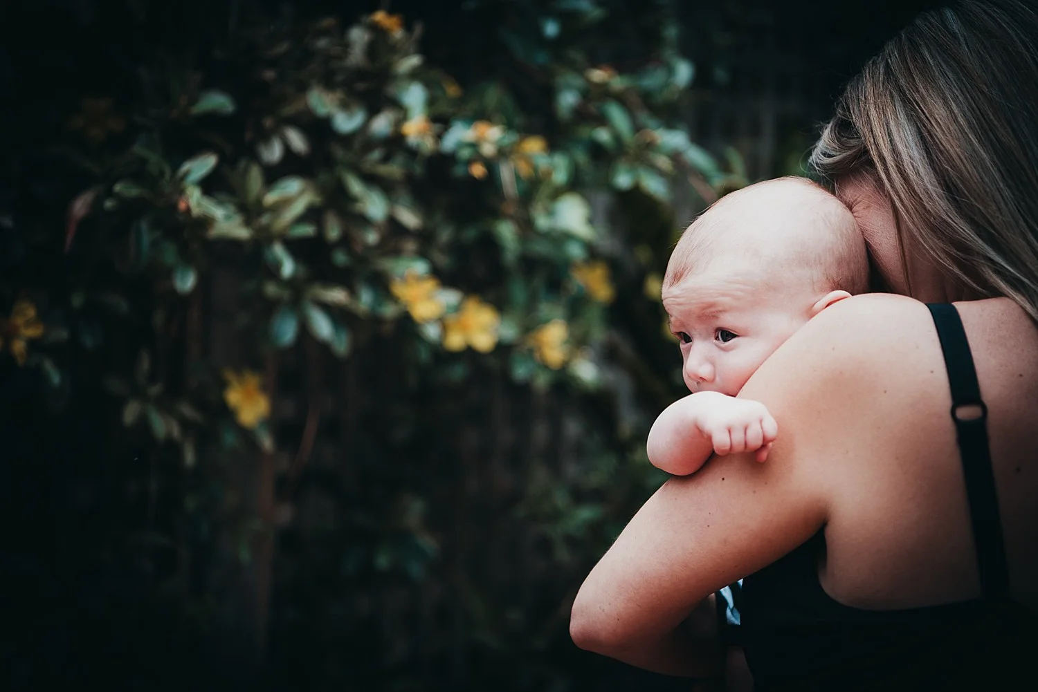 baby peeking from mothers arms