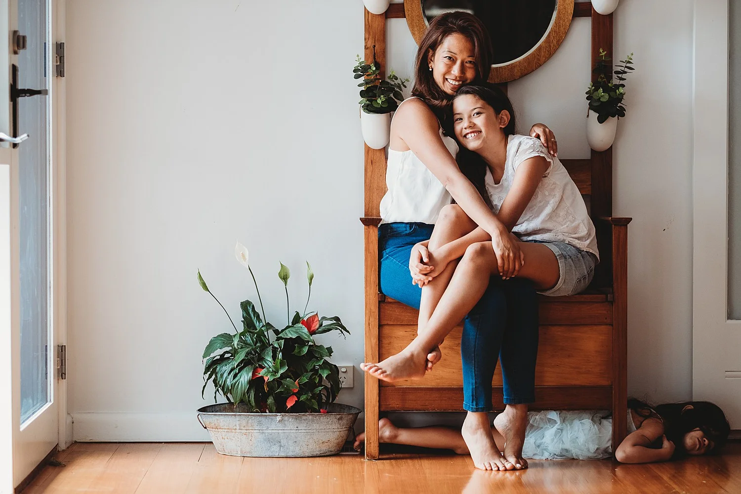 mother and daughter sitting on seat with little sister 