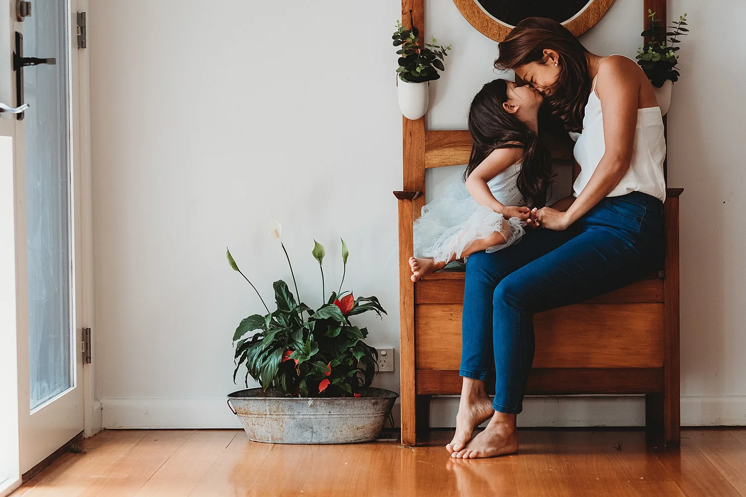 mother and little girl eskimo kiss on seat