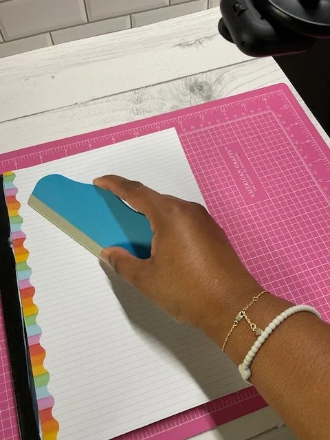 Placing scrapbook paper cover on notebook