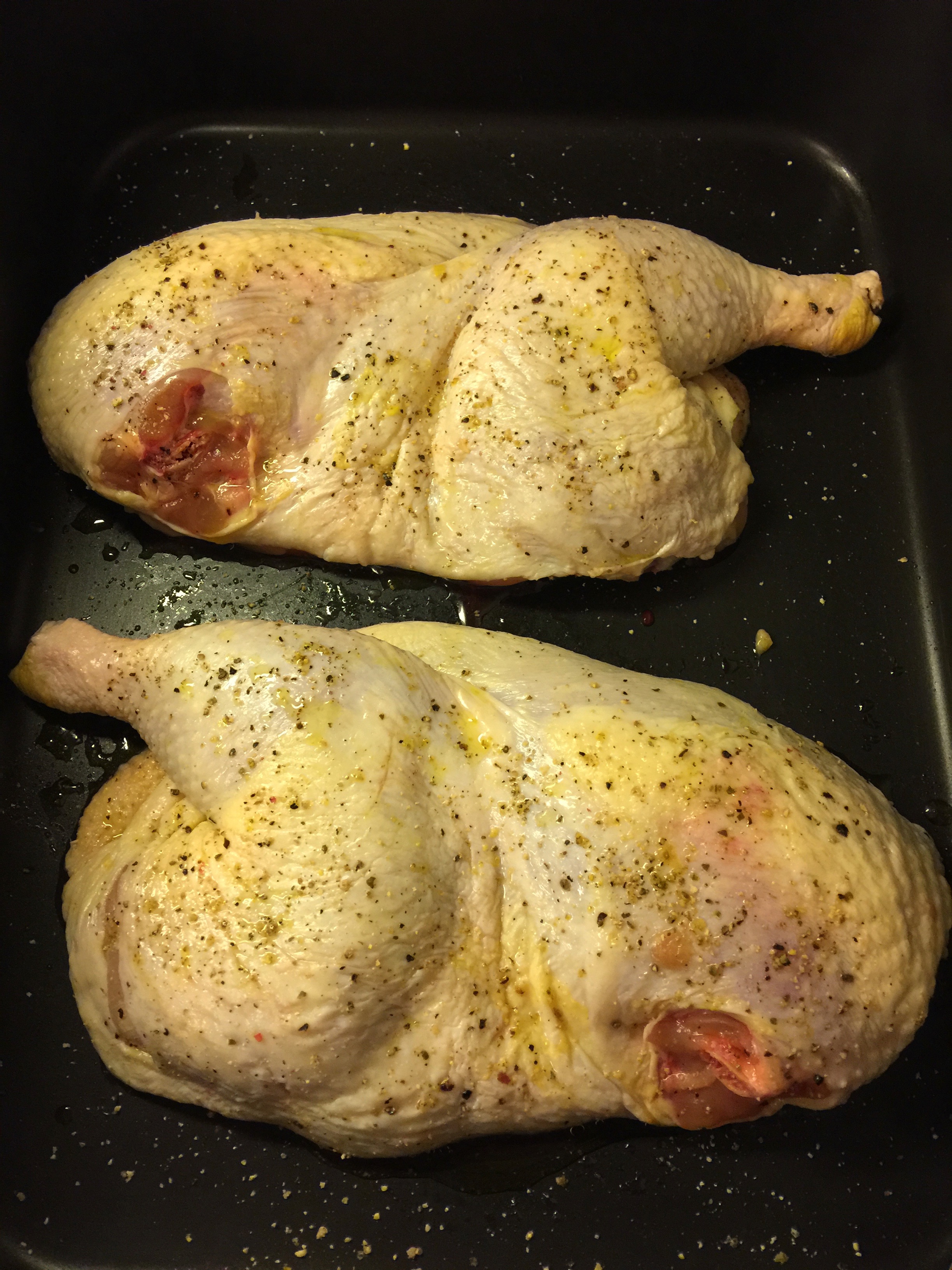 It doesn't get much simpler than this--the two chicken halves go in the roasting pan, fat side up, with just a little olive oil, salt and pepper on each side.