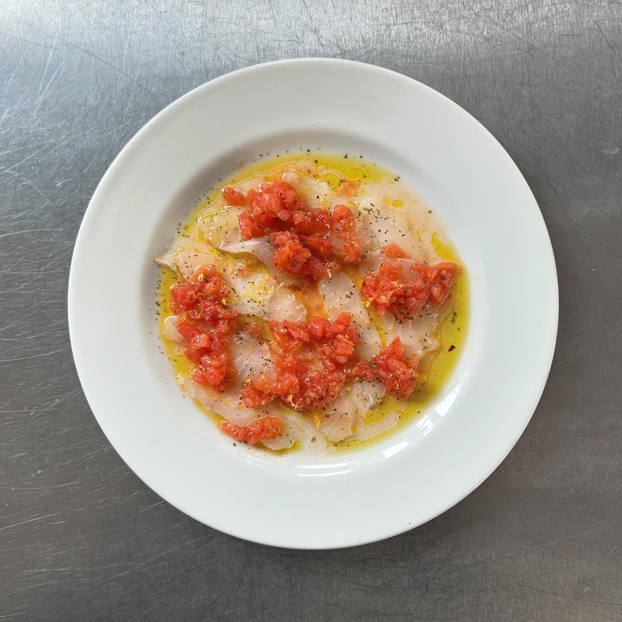 A plate of lightly salted pollock by chef Toby that we&rsquo;ve dressed up with chopped tomatoes, chilli and oregano and @honest_toil. It feels a bit like summer and that&rsquo;s what we like.