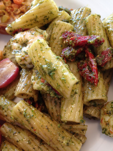 My favorite way to eat pesto--tossed with hot pasta, sundried tomatoes (or fresh halved cherry tomatoes if they are in season), and a few cubes of fresh mozzarella cheese. I also put shrimp in the dish this time, which was delish. You can top with grilled chicken breast (or slice it up), cubes of hard salami, or even saute some Italian sausage. Pesto is so versatile....start your imagination engine and have some fun!