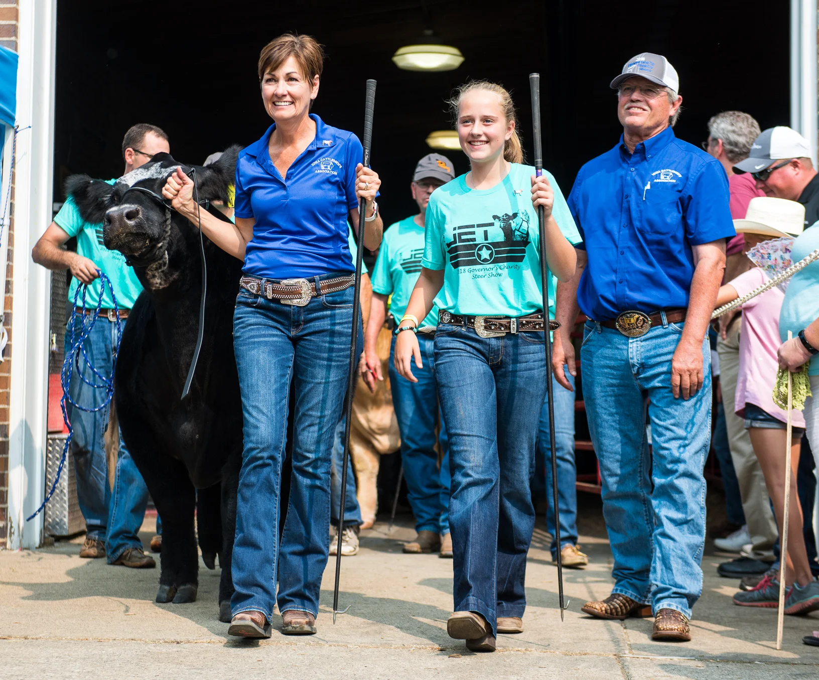 Governor Kim Reynolds and Tyler Pudenz lead Jet out of the livestock barn during the parade to the Governor's Steer Show. Pudenz said she usually doesn't get nervous until she enters the ring before a show. Photo credit: Joseph L. Murphy/Iowa Soybean Association