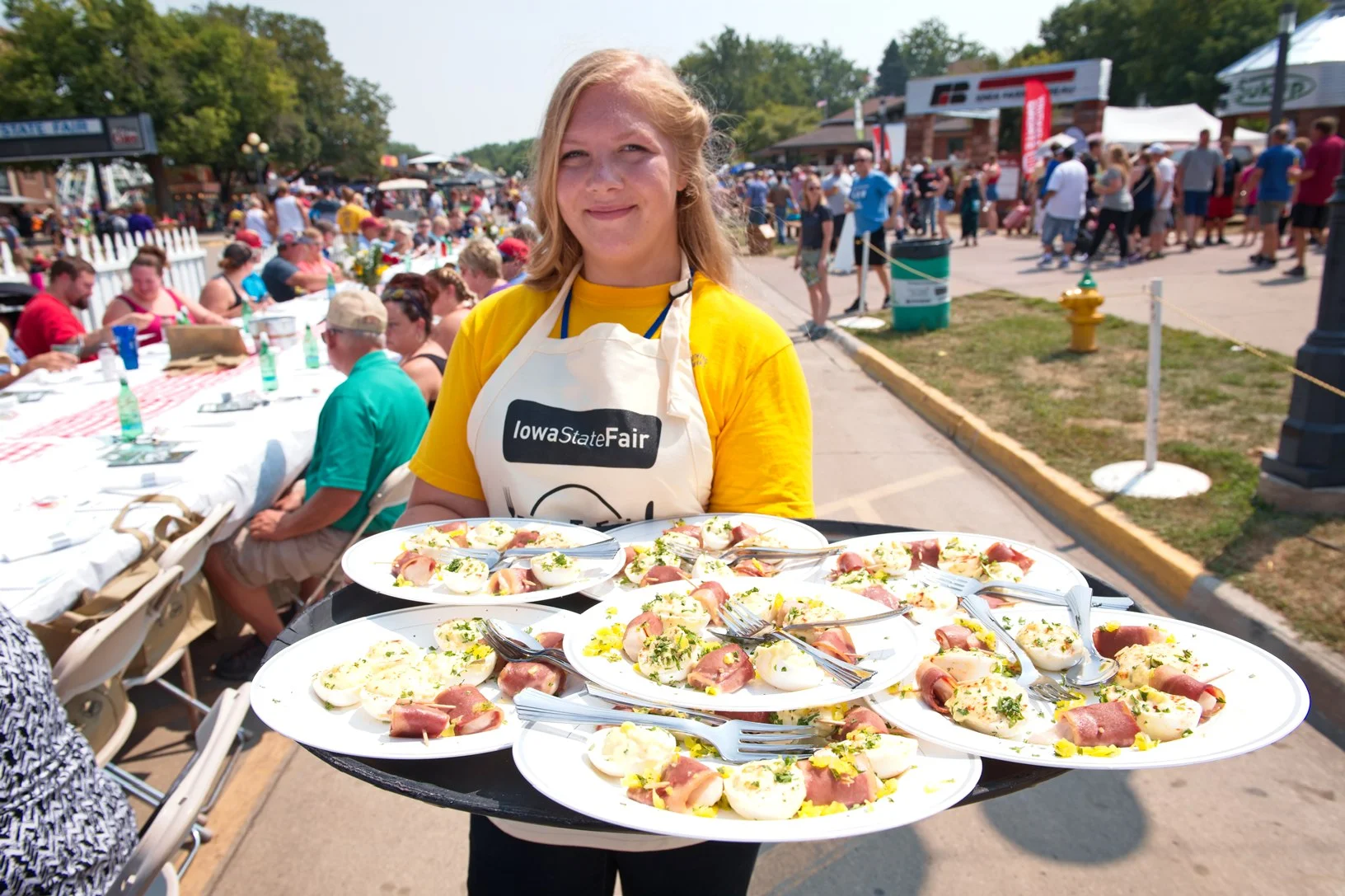 Hailey Bates, ACGC FFA, prepares to serve food to the participants of the first Farm to Table event at the Iowa State Fair. Bates and other FFA students helped serve the food that had ingredients from all of Iowa’s commodity groups. Photo credit: Joseph L. Murphy/Iowa Soybean Association