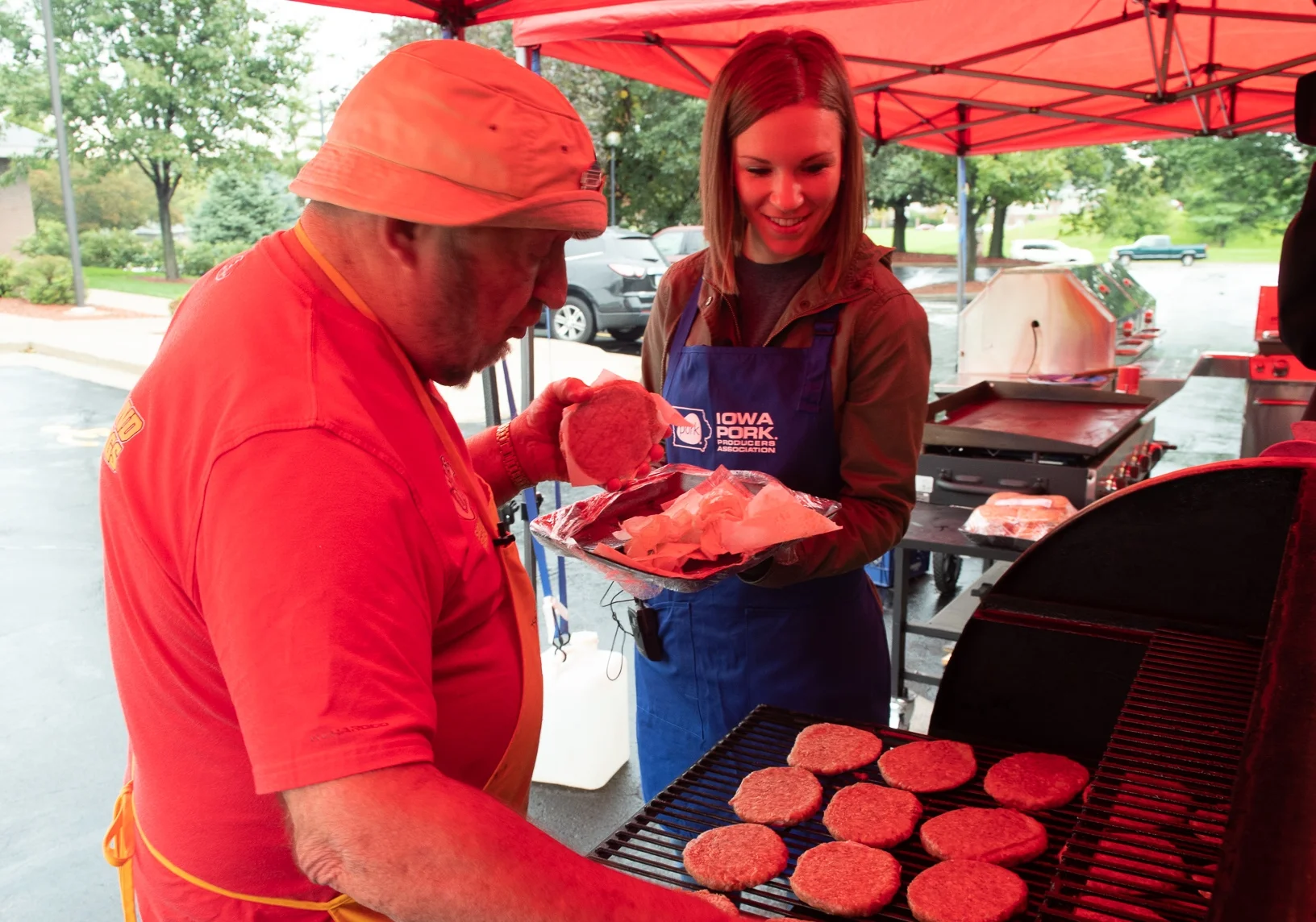 Kelsey Byrnes, consumer outreach director for Iowa Pork, and Speed Herrig grill Cookies BBQ pork patties from the Hy-Vee meat counter. Photo credit: Joseph L. Murphy/Iowa Soybean Association