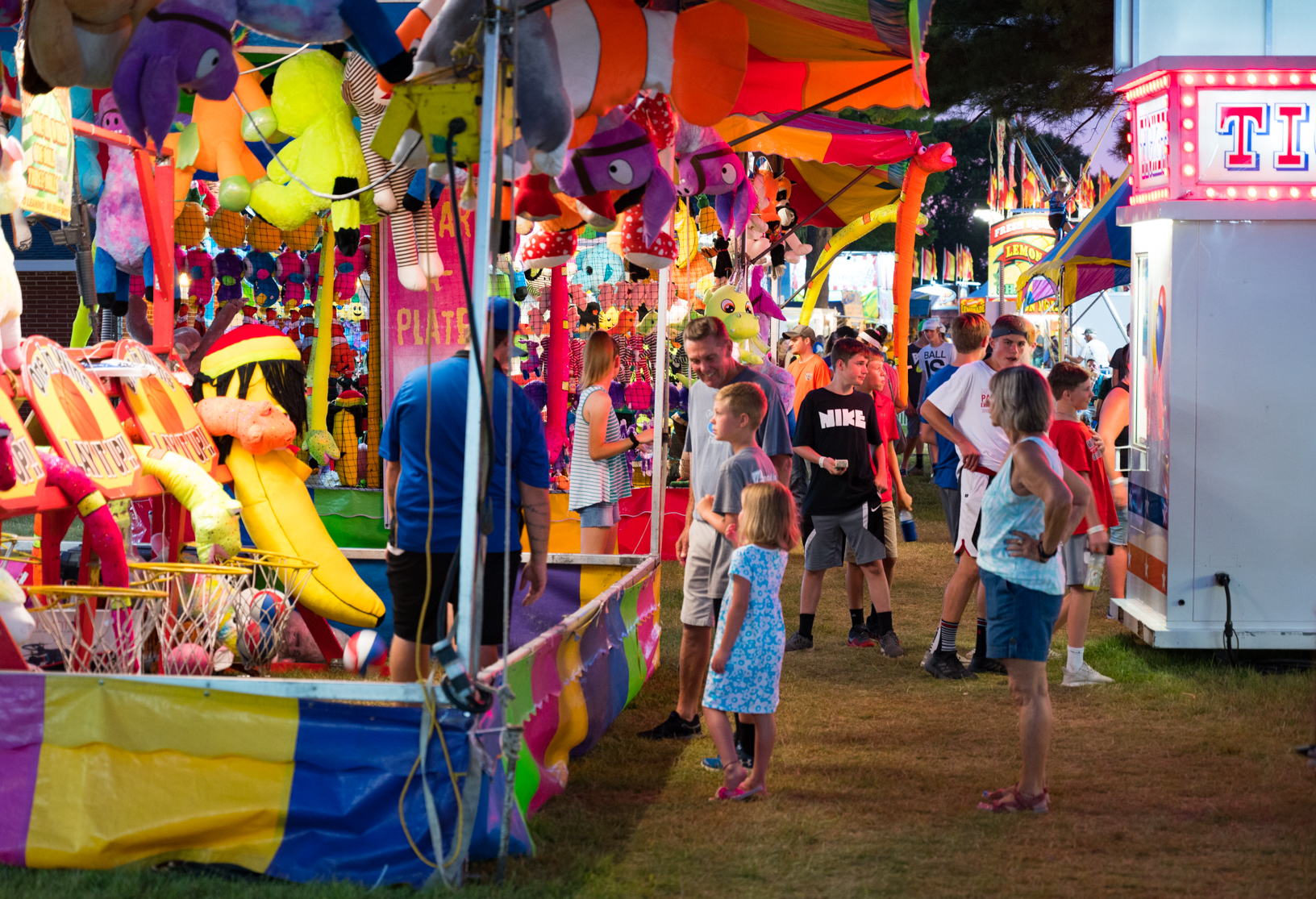 A family tries their luck at a midway game during the Jones County Fair. Photo credit: Joseph L. Murphy/Iowa Soybean Association