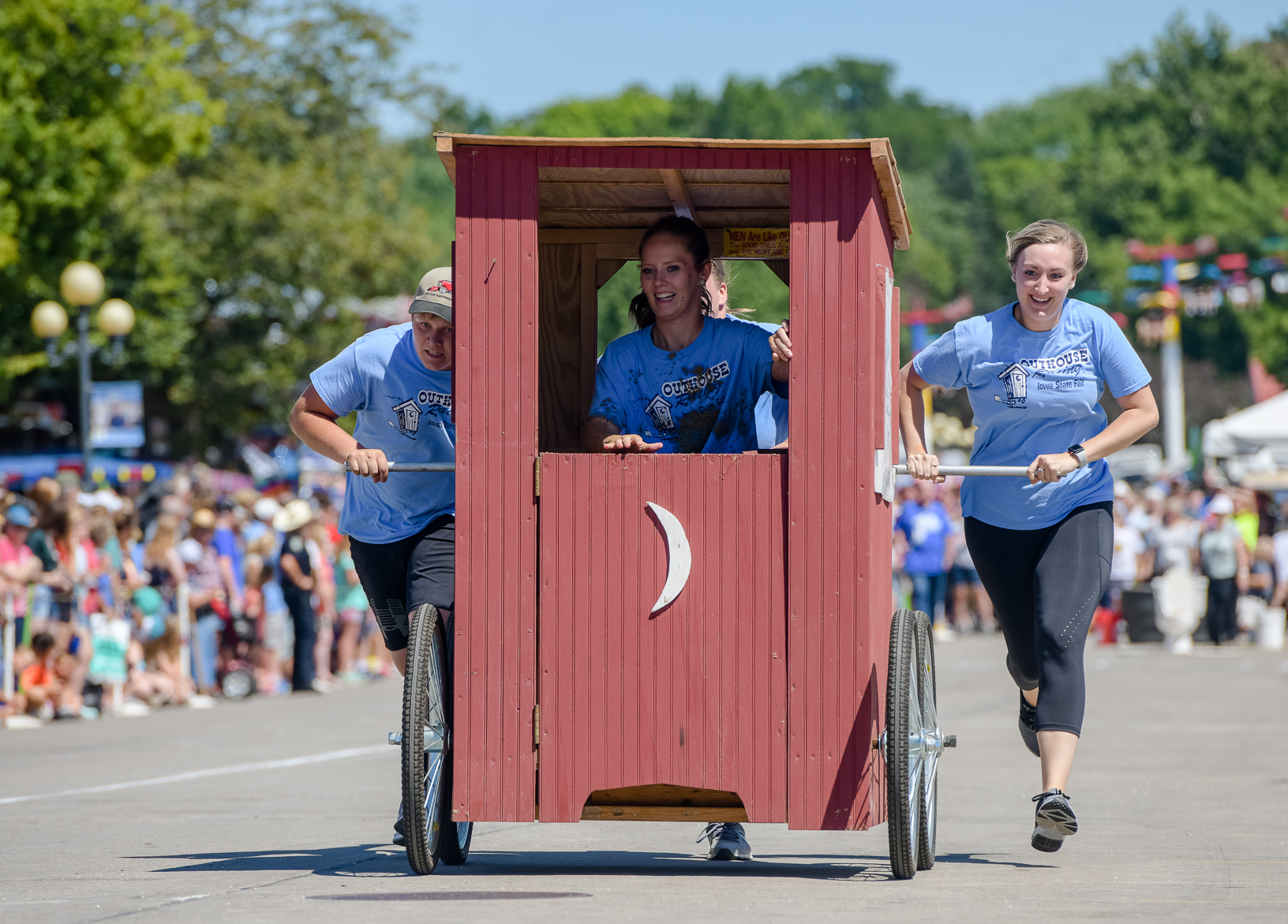 A team competes in the outhouse race on the Grand Concourse of the Iowa State Fair. The outhouse race is where teams create home-made outhouses on wheels and compete in a relay race. Photo credit: Joseph L. Murphy/Iowa Soybean Association