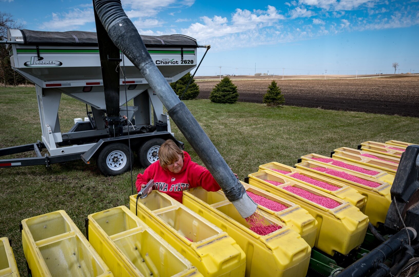  April Hemmes, a farmer from Hampton, fills a planter with soybeans on the first day of planting in April. Hemmes and other farmers across the state planted their crops under the uncertainty of a trade war with China and an emerging pandemic. 