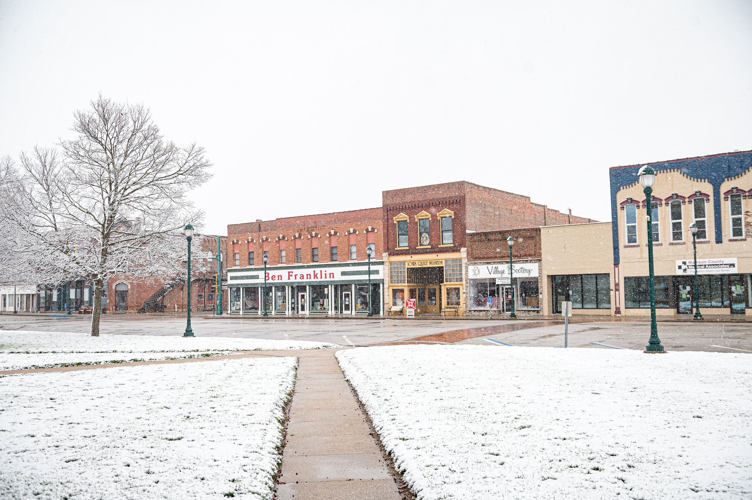  Small businesses felt the pandemic's impacts on main streets and town squares across the country. Here, spring snow falls on an empty Winterset town square in April. 