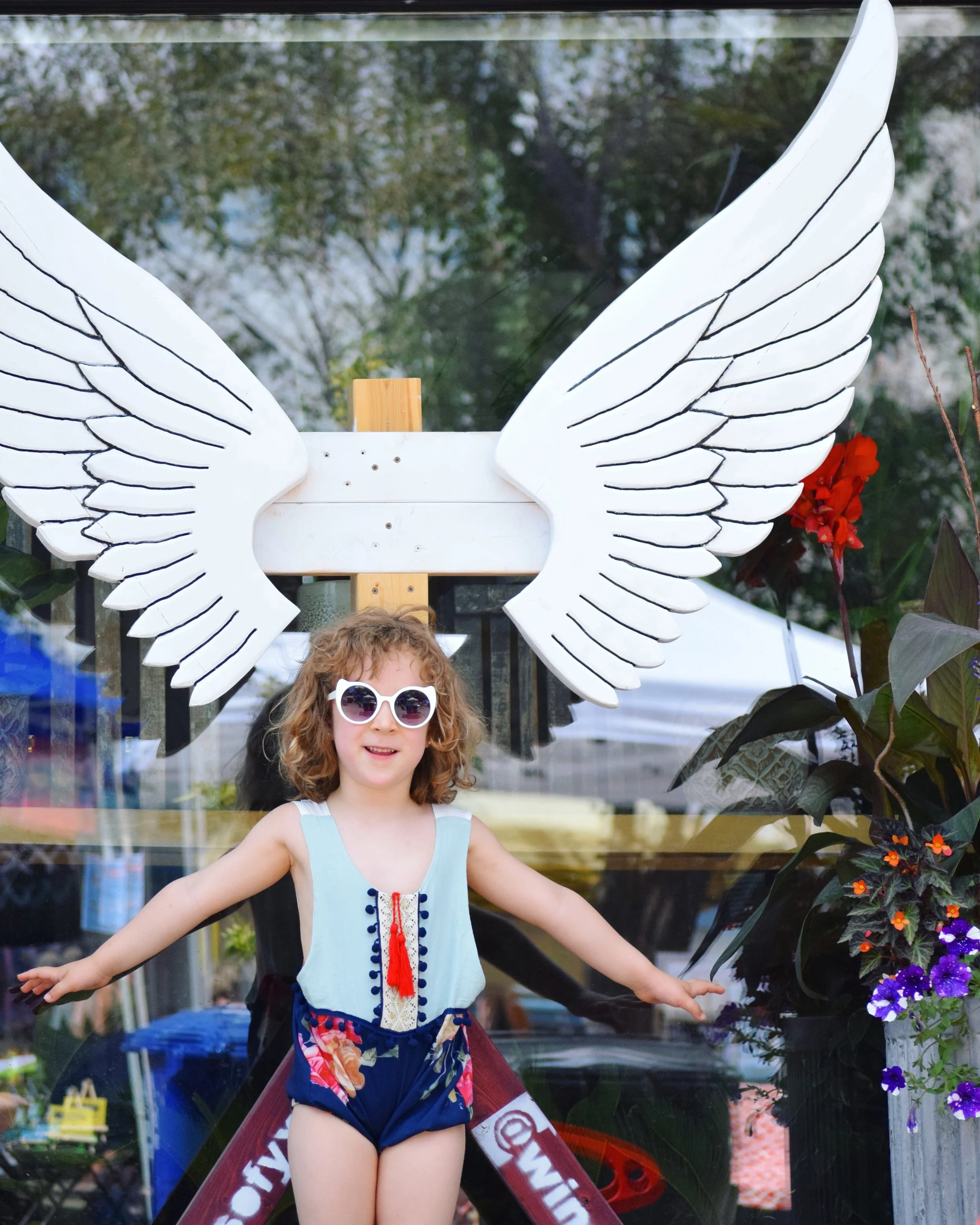 My daughter poses with a set of wings during the Fringe Festival on Broadway.