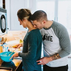 A couple cooking together in a kitchen.