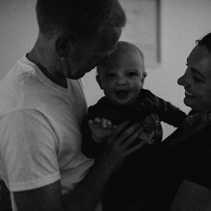A man and woman holding a smiling baby together.